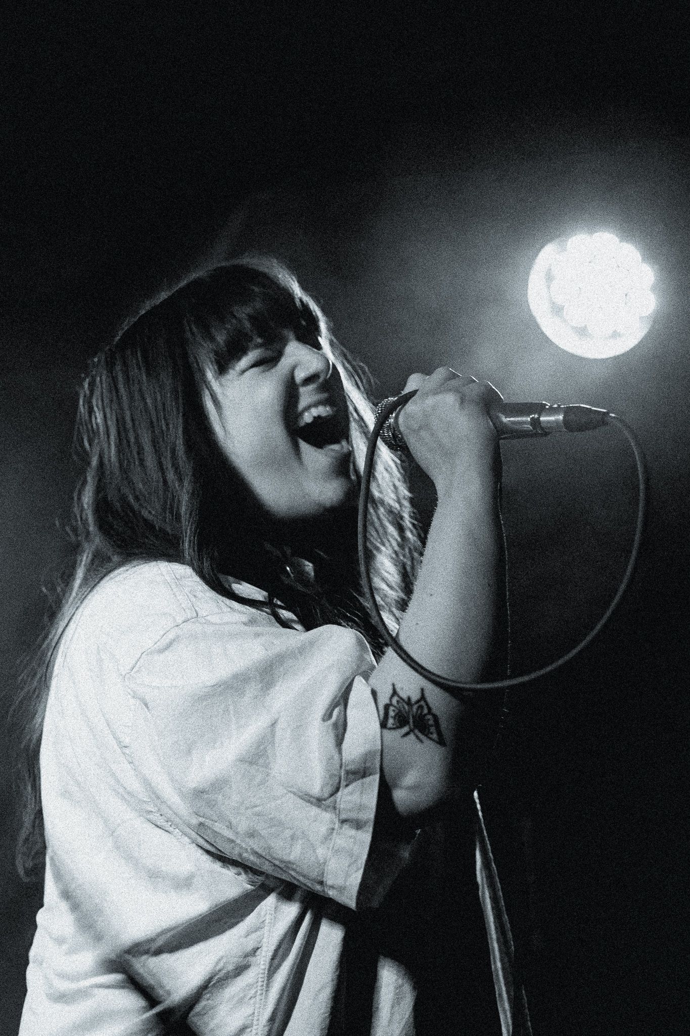 A series of black and white performance photos showing a singer passionately performing on stage with a microphone.
