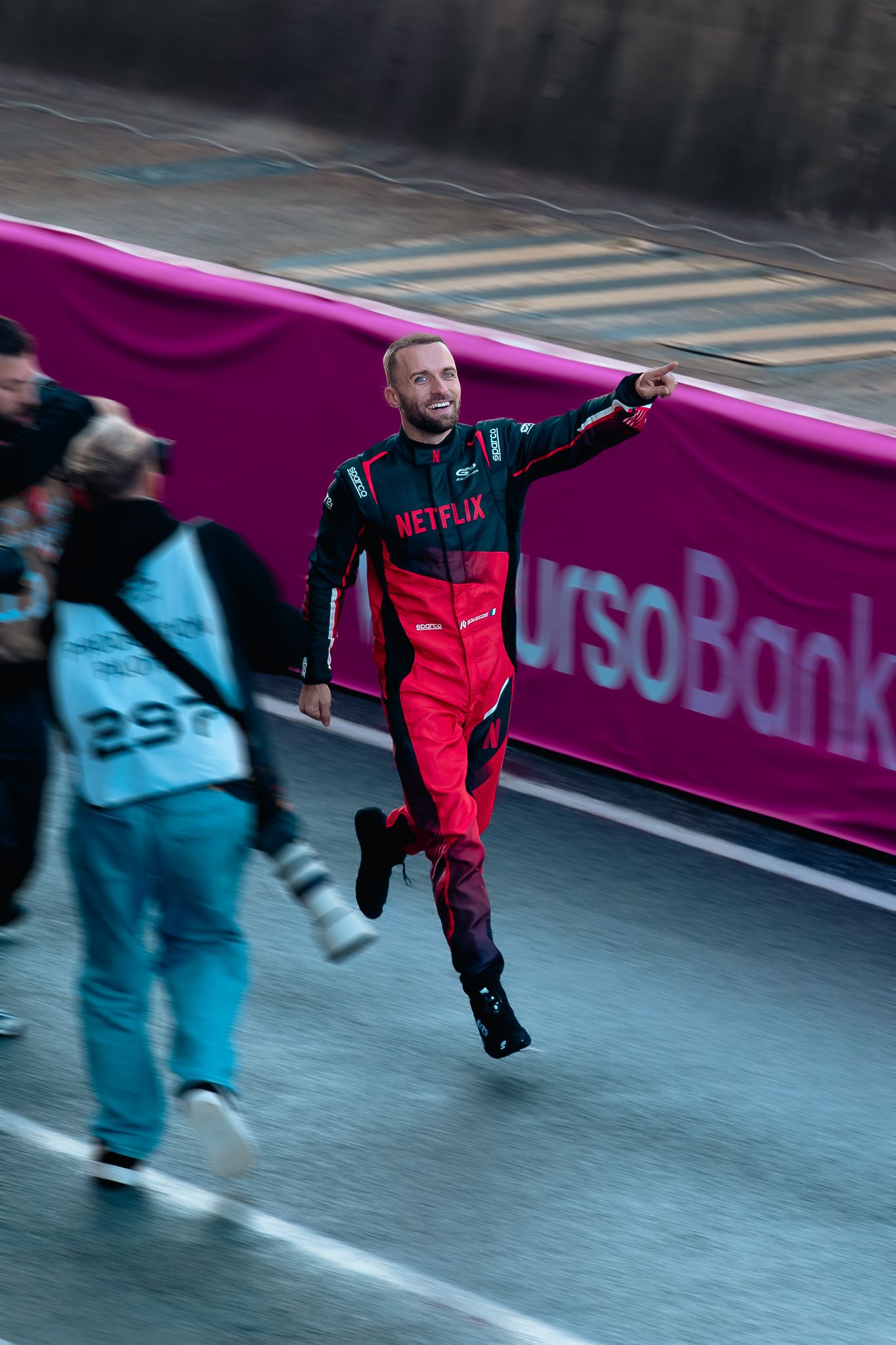 Sequence of a person in red and black outfit performing a high kick move while others in blue outfits watch.