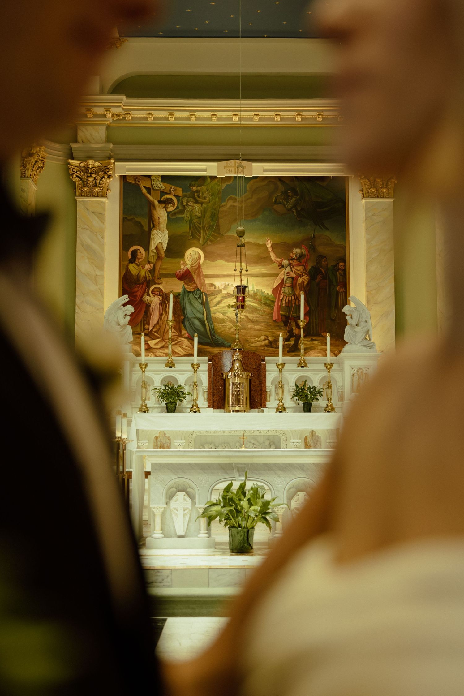 Interior of a church altar with ornate religious paintings and decorative columns.
