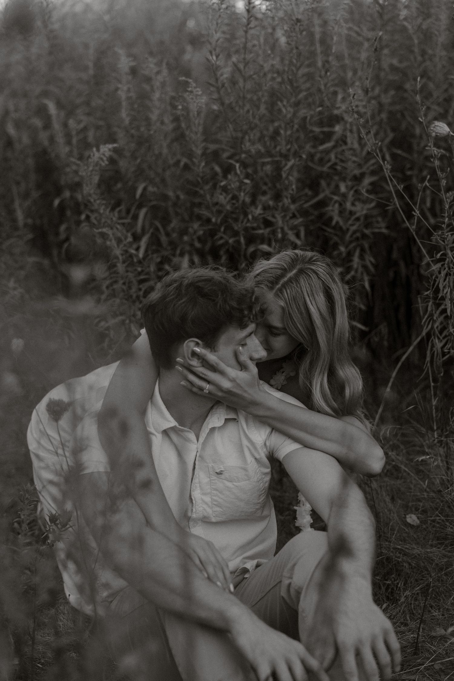A romantic black and white photo sequence shows two people embracing and kissing in a natural outdoor setting.