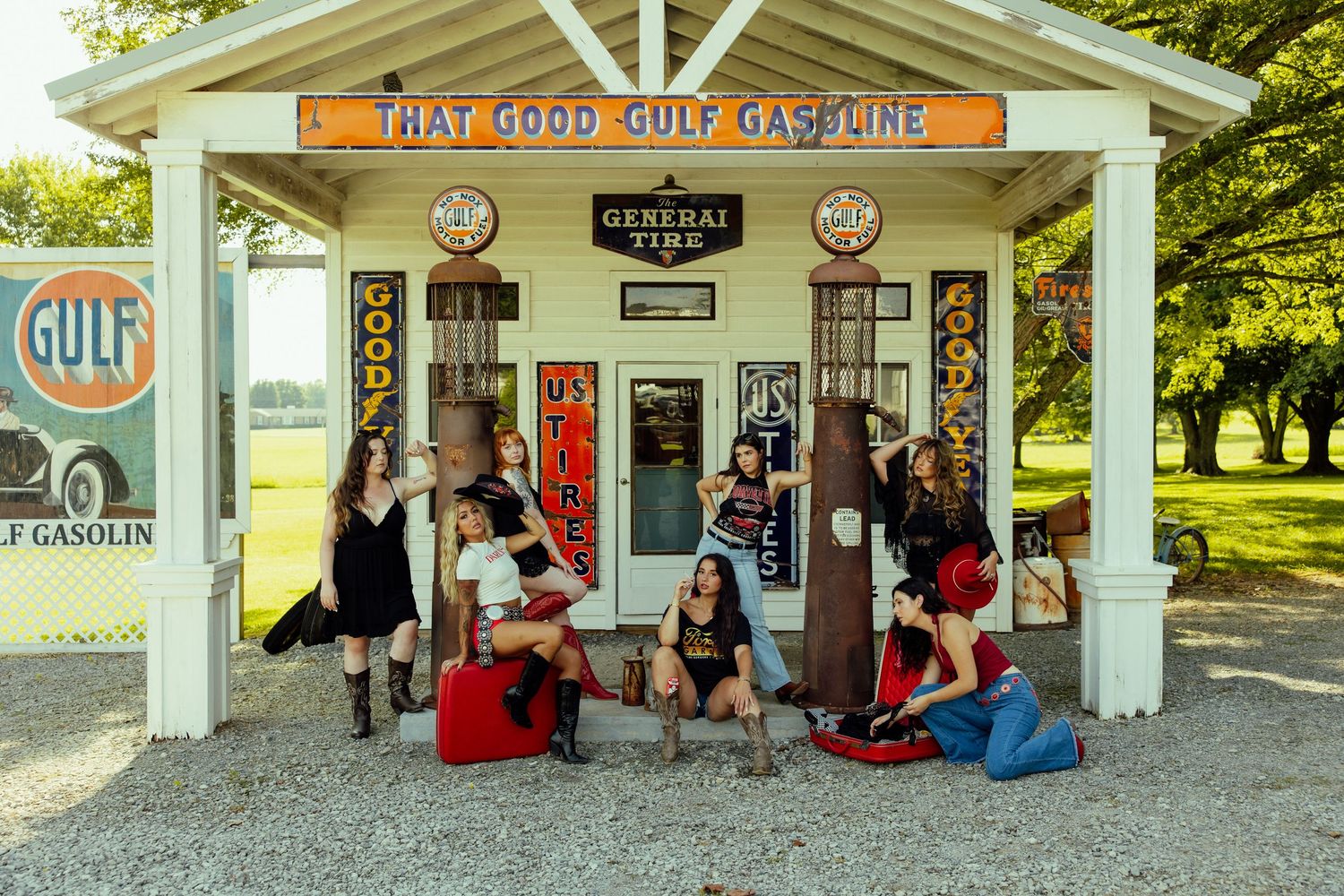 People gather outside a vintage Gulf gas station with red Coca-Cola machines and nostalgic signage.