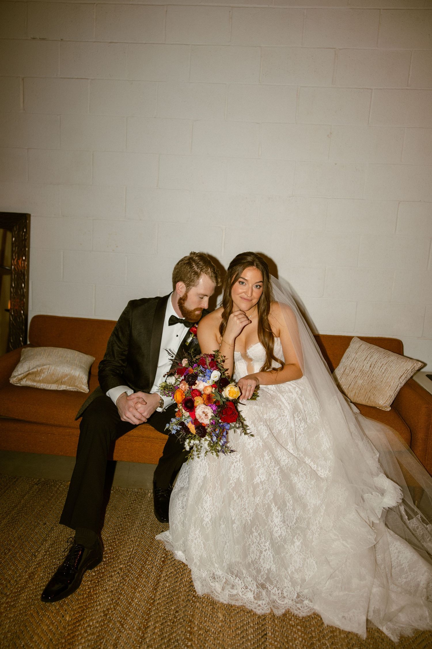 A wedding couple poses together on a carpeted floor in a series of candid moments.