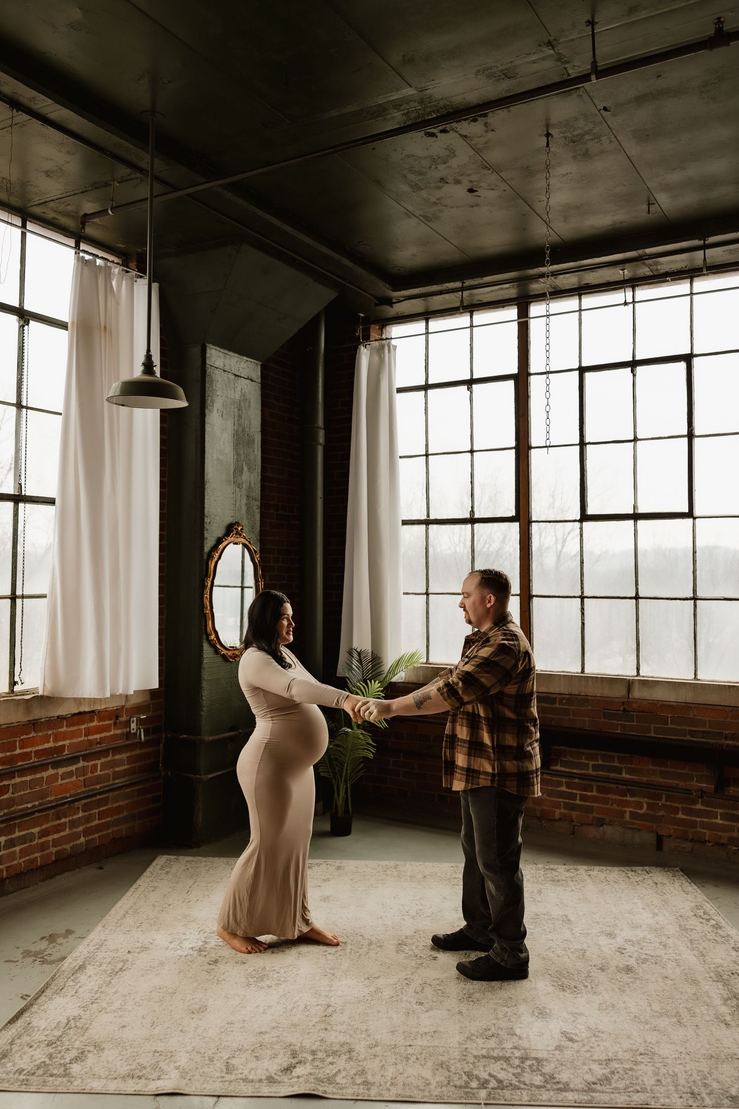 A sequence of images showing a dramatic dance performance in an industrial loft space with brick walls and large windows.