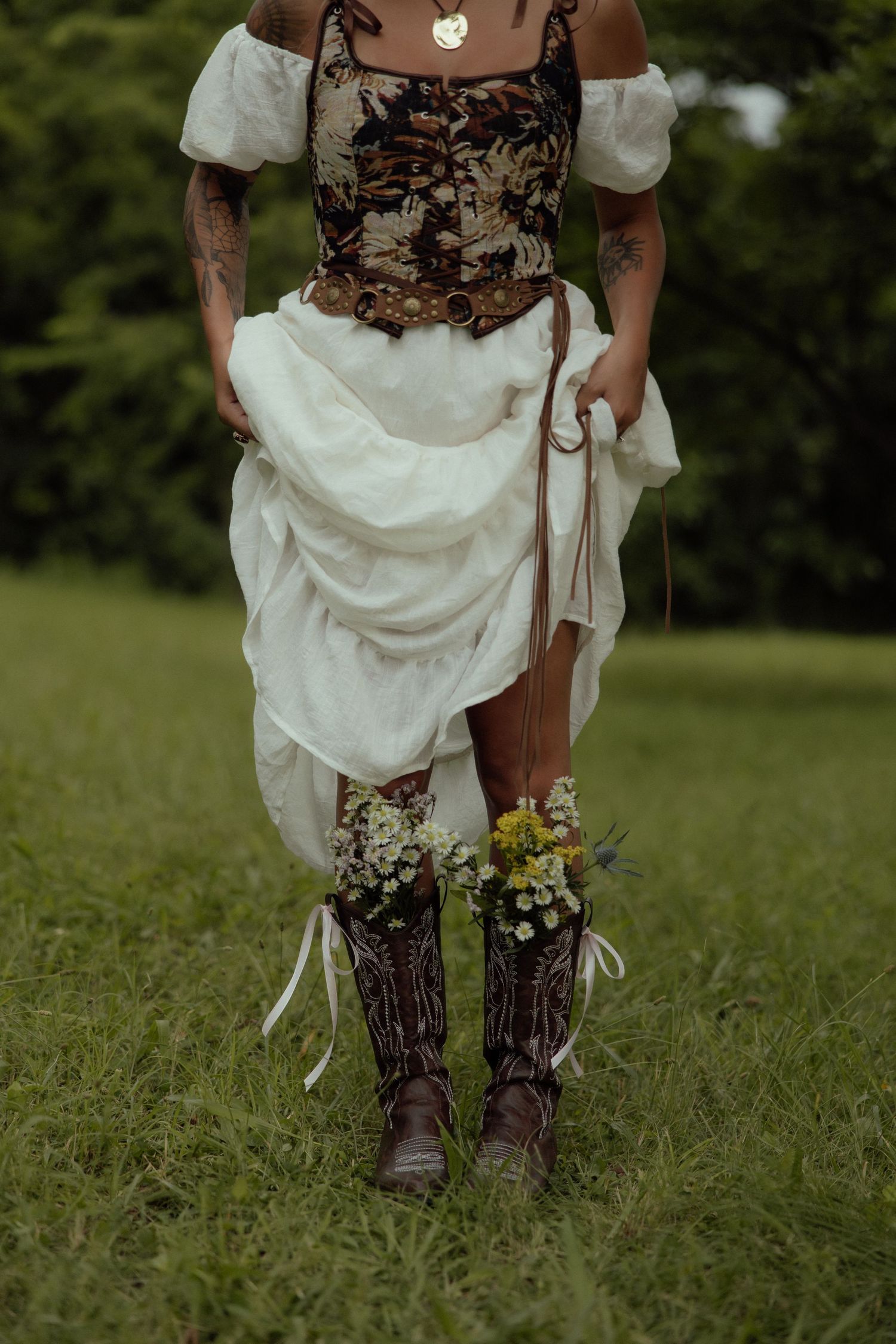 White dress and brown patterned boots shown against green grass in an artistic outdoor portrait.