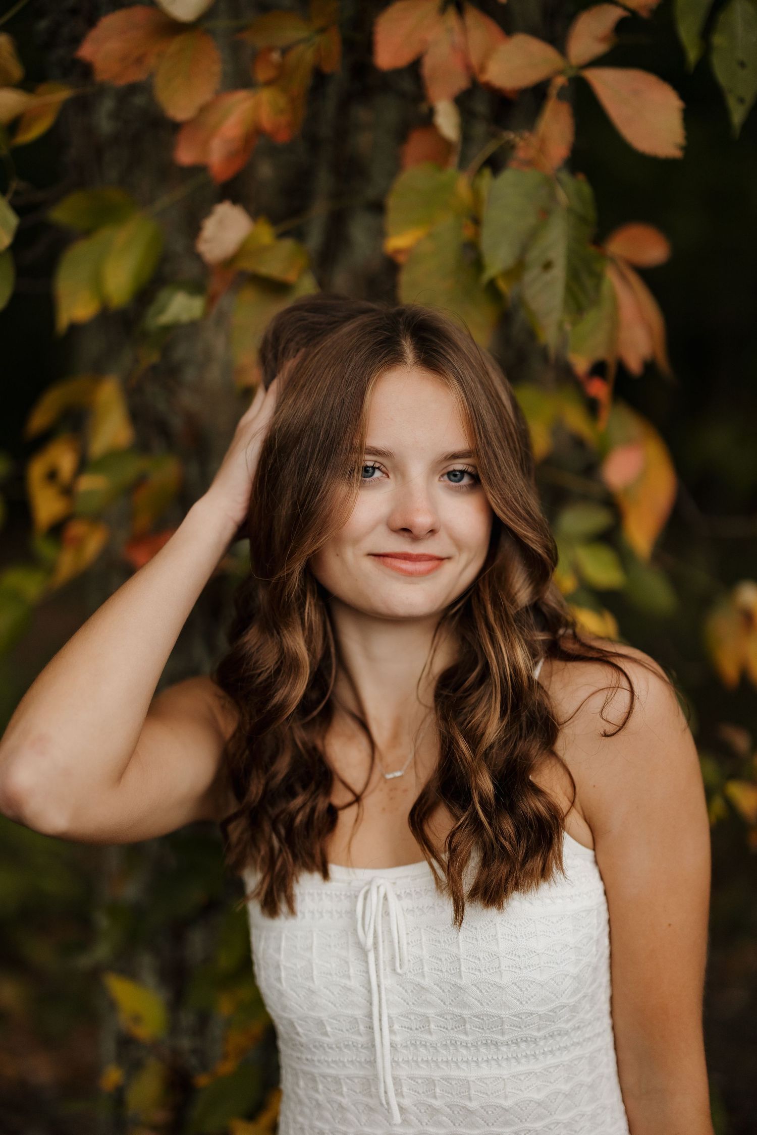 Close-up autumn portrait with colorful fall leaves in the background.