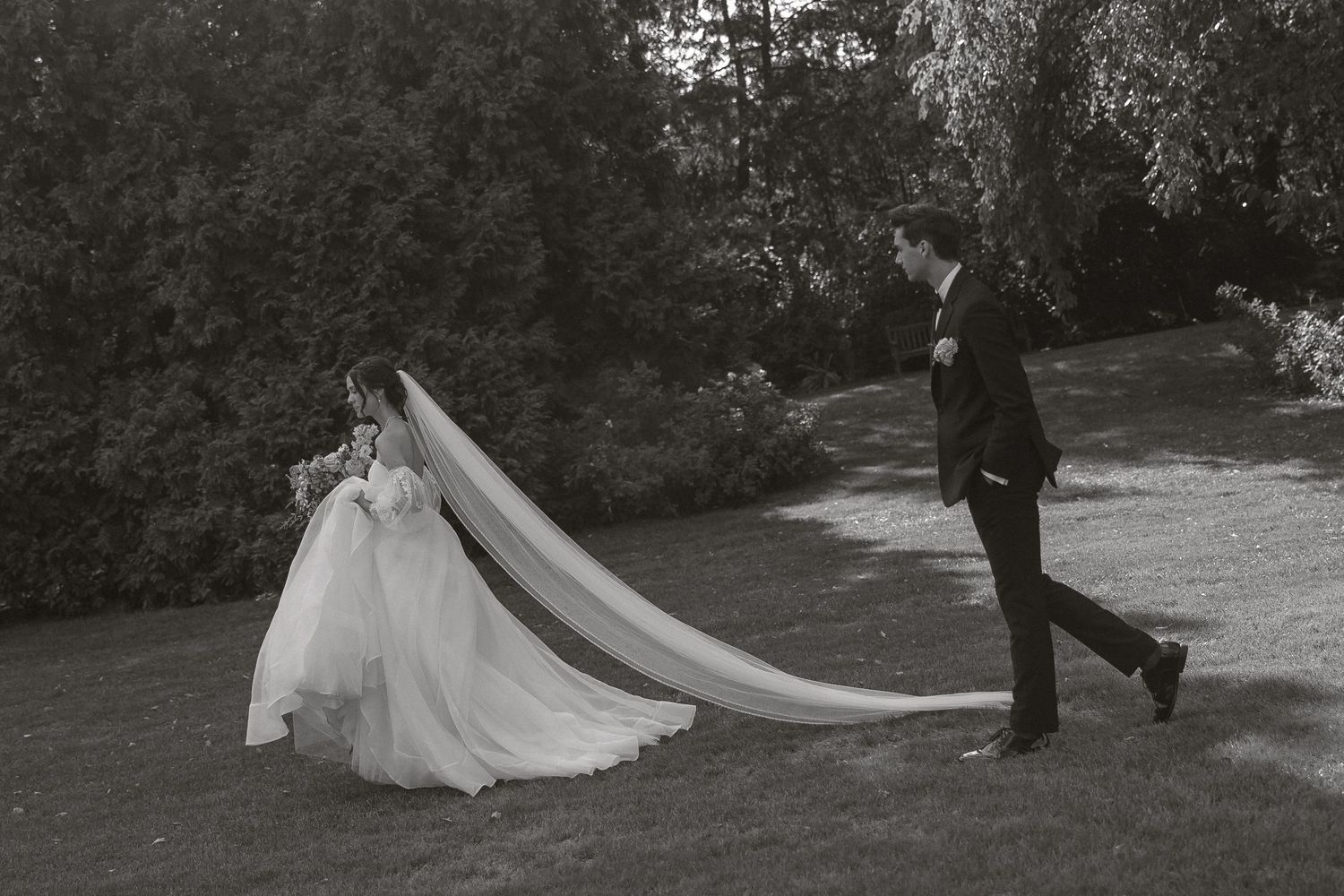 A series of black and white wedding photos showing a couple walking through a garden setting.