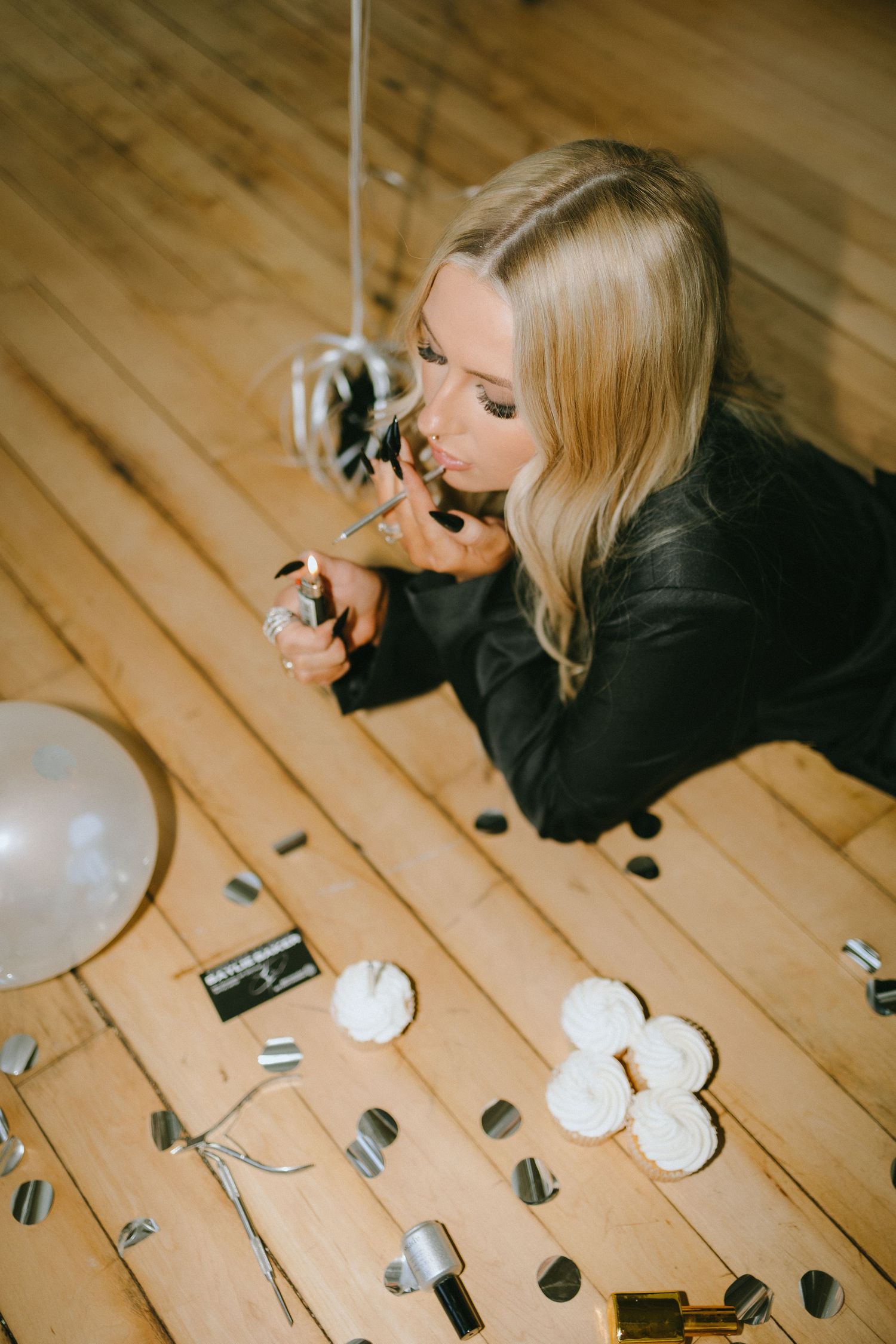 Overhead shot on wooden floor with white balloons and decorative elements.