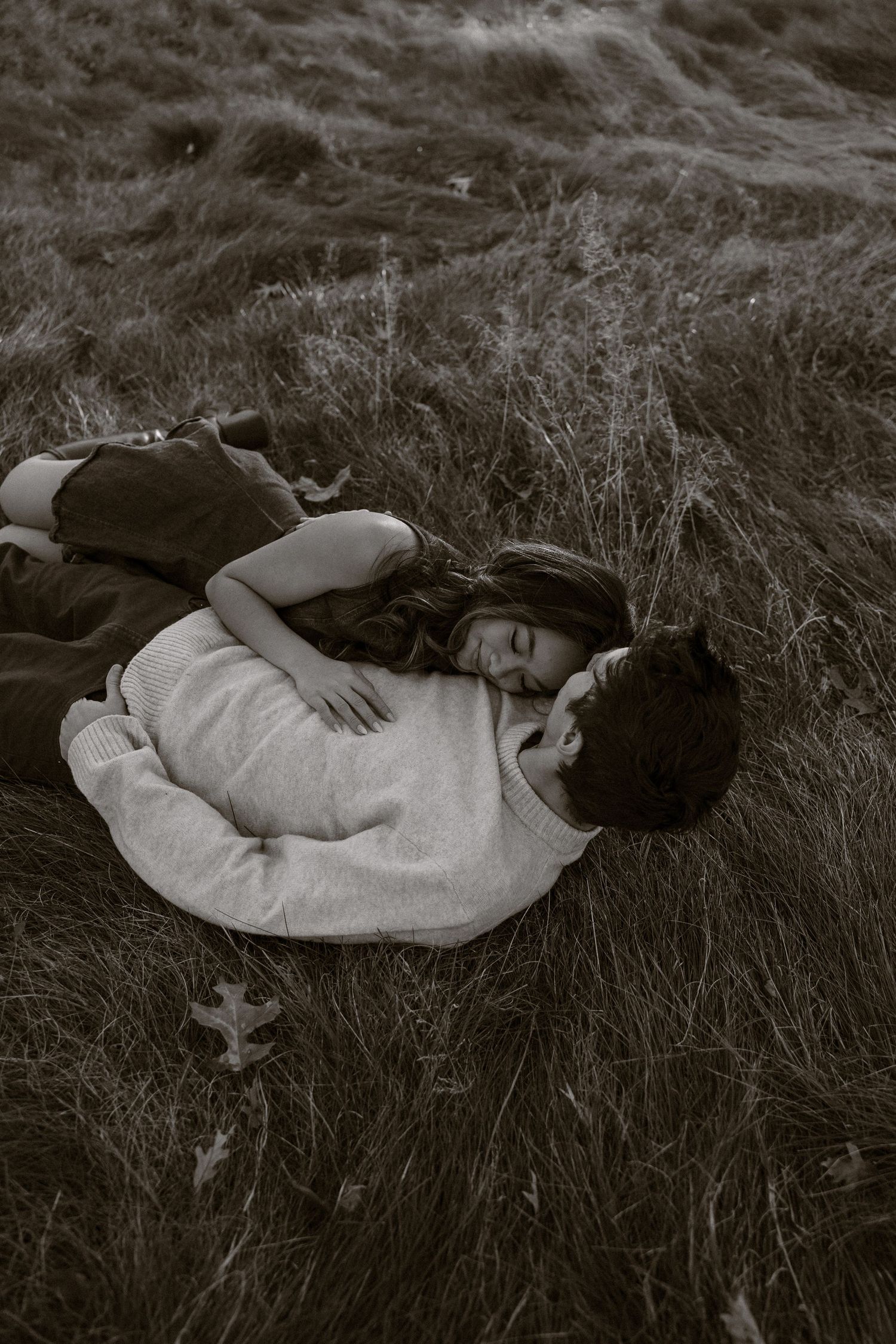 A series of black and white photographs showing someone lying peacefully in tall grass.