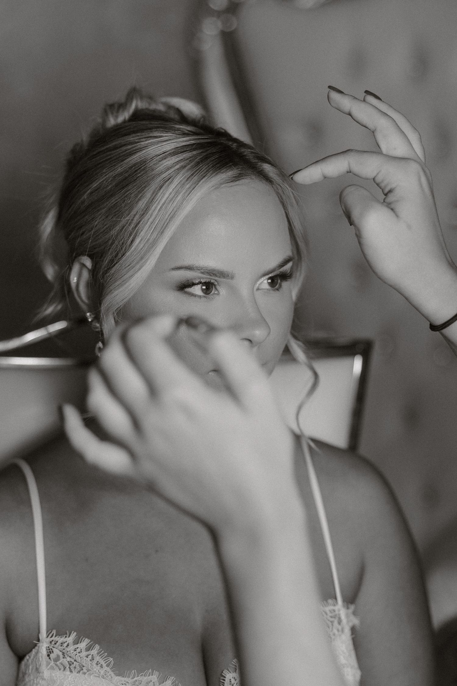 A black and white sequence showing someone applying makeup in close-up shots.