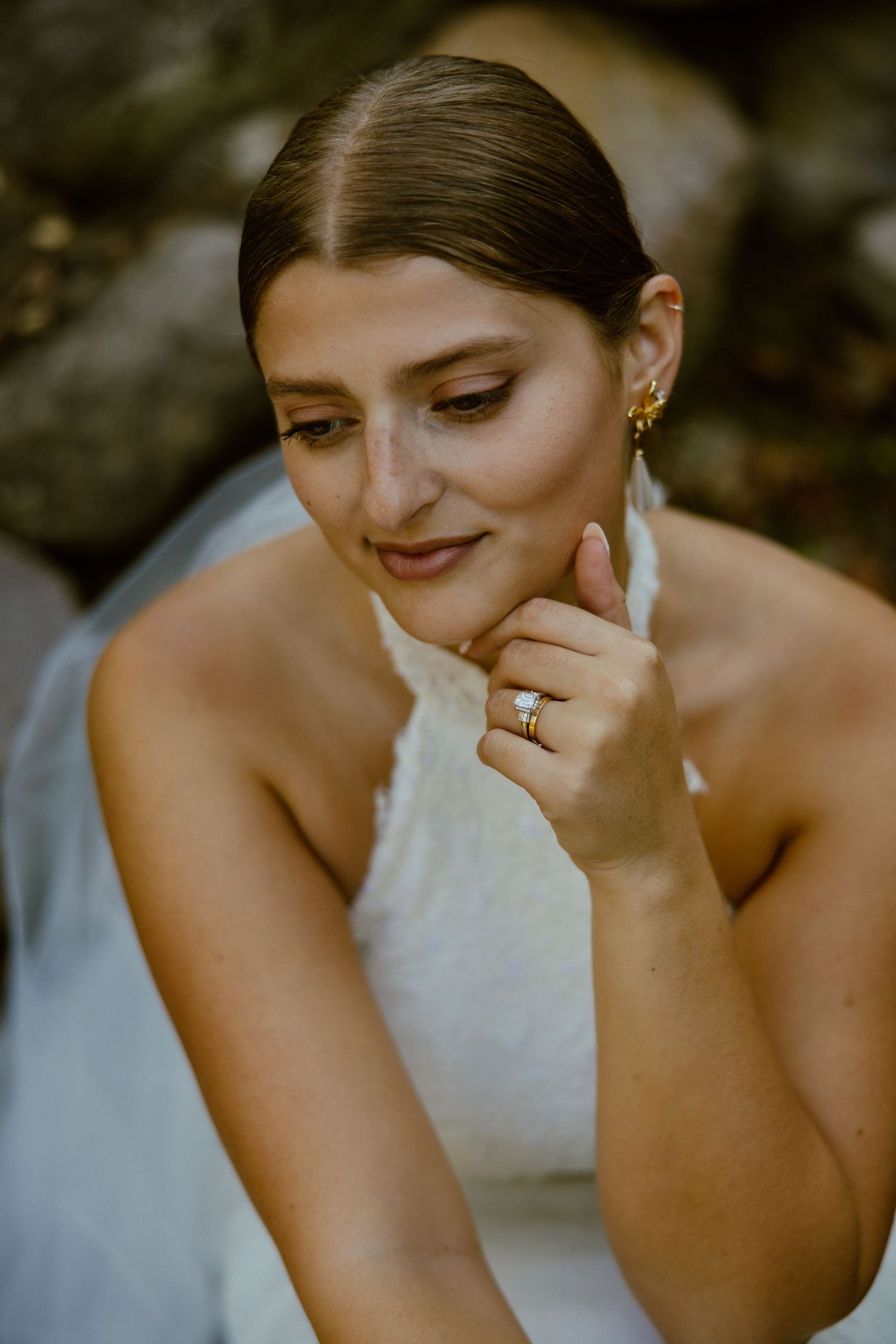 Close-up portrait showing a joyful emotional moment with a white wedding dress and delicate jewelry.