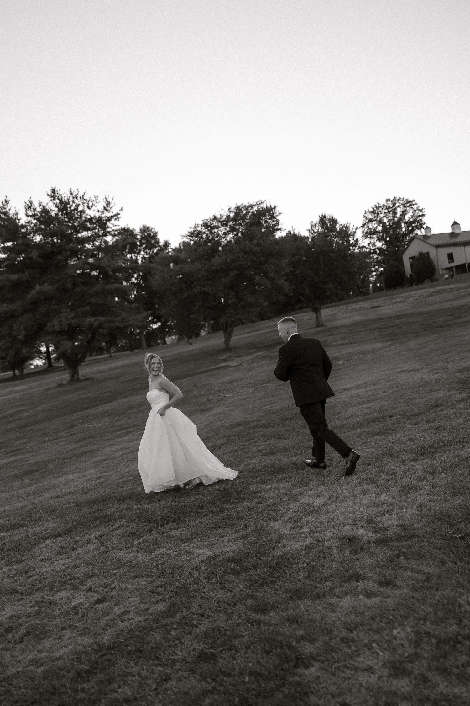 Black and white photo sequence of newlyweds running playfully across a grassy hillside.