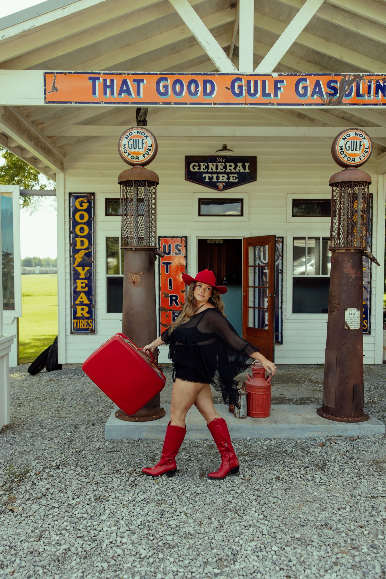Retro gas station scene with Gulf gasoline signage and gravel ground featuring red and black fashion elements.