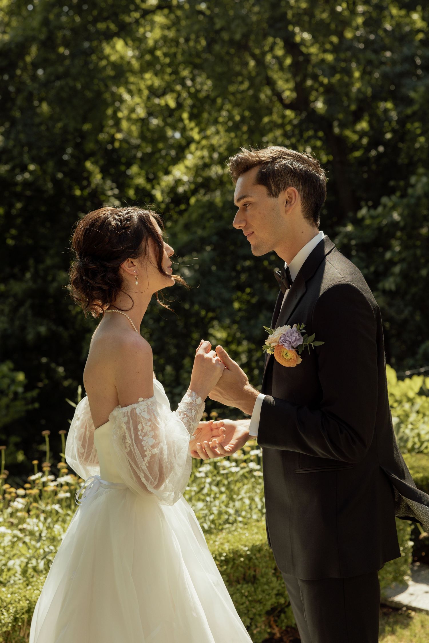 A bride and groom share romantic moments in a sunlit garden setting.