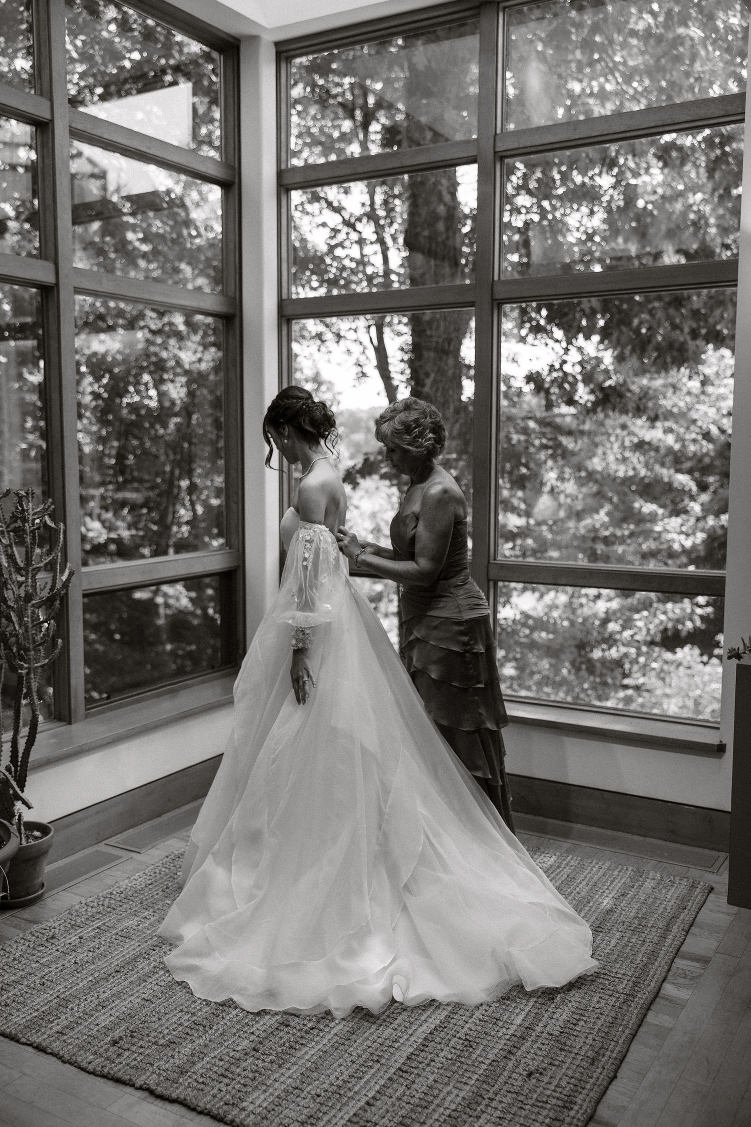 Black and white photo series showing a flowing wedding dress silhouette against large windows in a sunlit room.