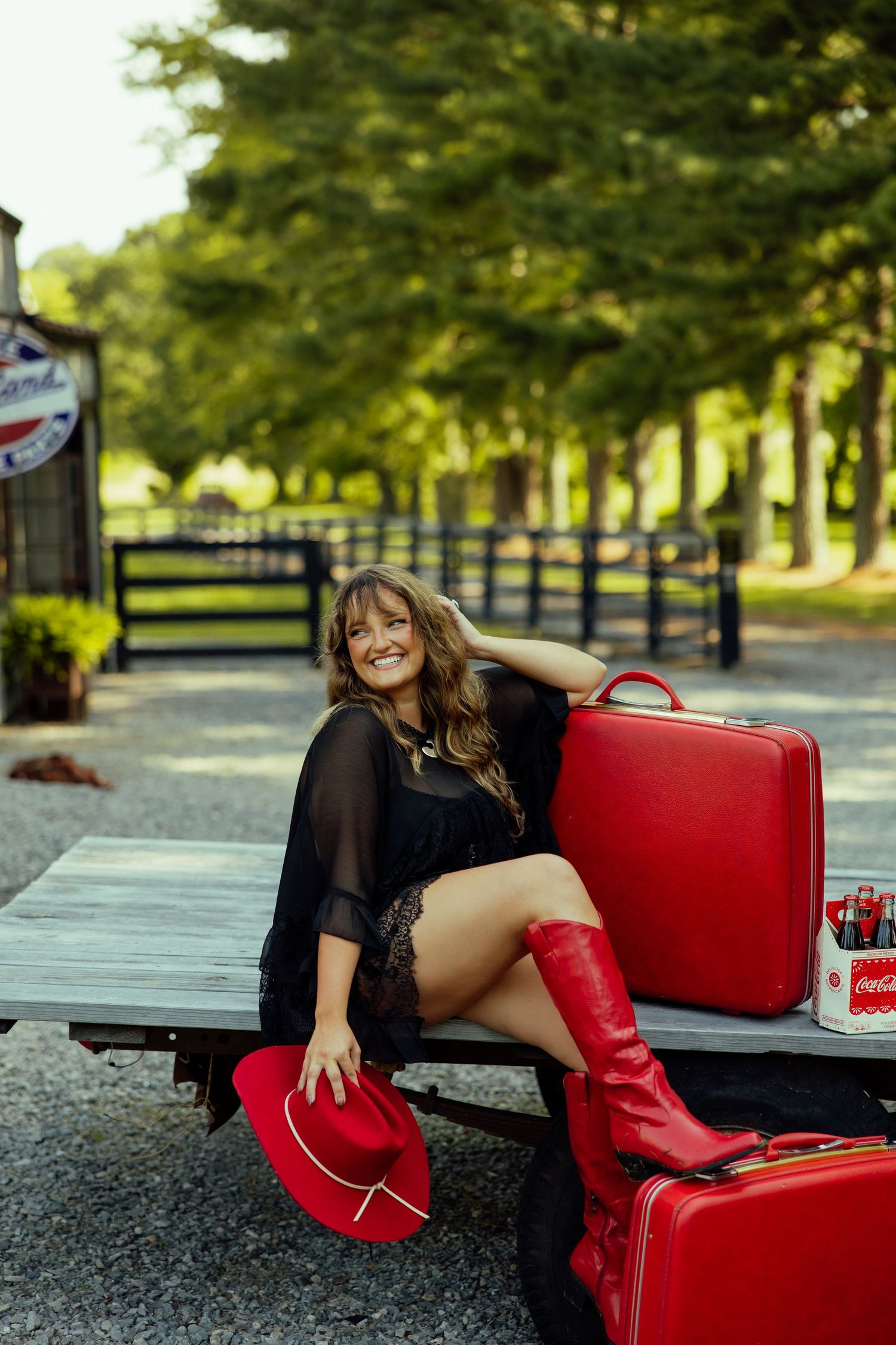 Red vintage suitcases arranged on a wooden deck in an outdoor setting with trees in the background.