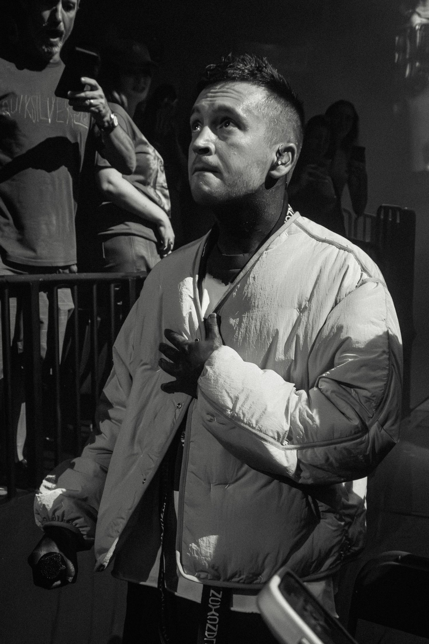 Black and white shot of performer wearing white puffer jacket during show.