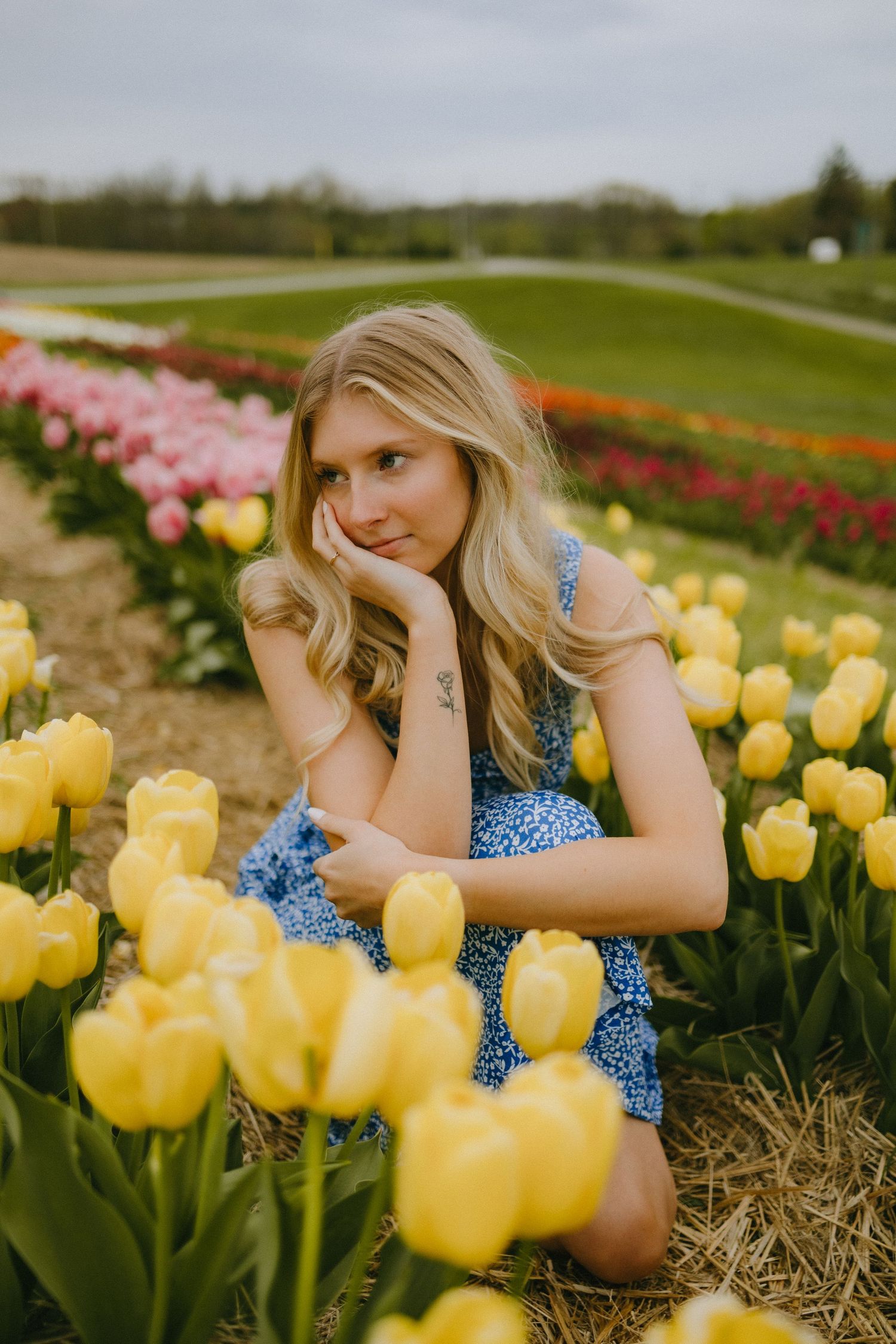 Spring portrait session with yellow tulips and blue floral dress.
