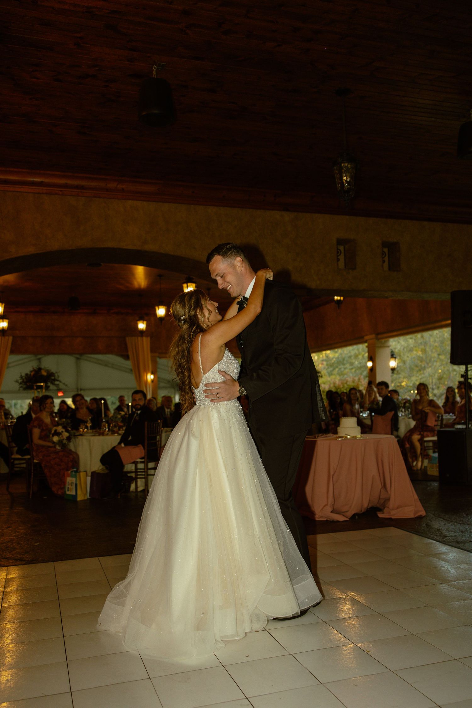 A wedding couple's first dance sequence on an elegant white dance floor at their reception.