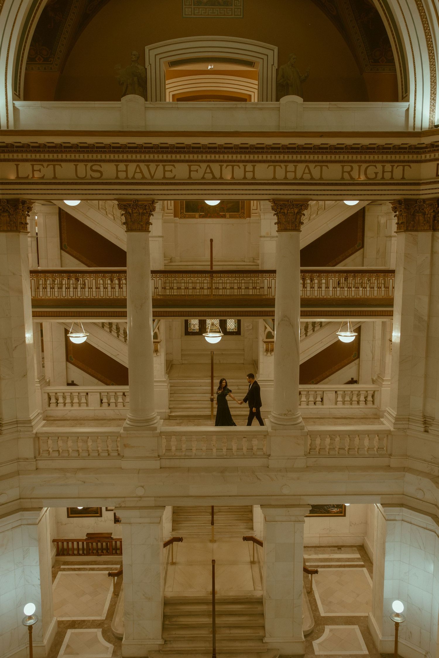 Interior of historic courthouse with classical columns and text reading 'Let us have faith that right' inscribed on upper wall.