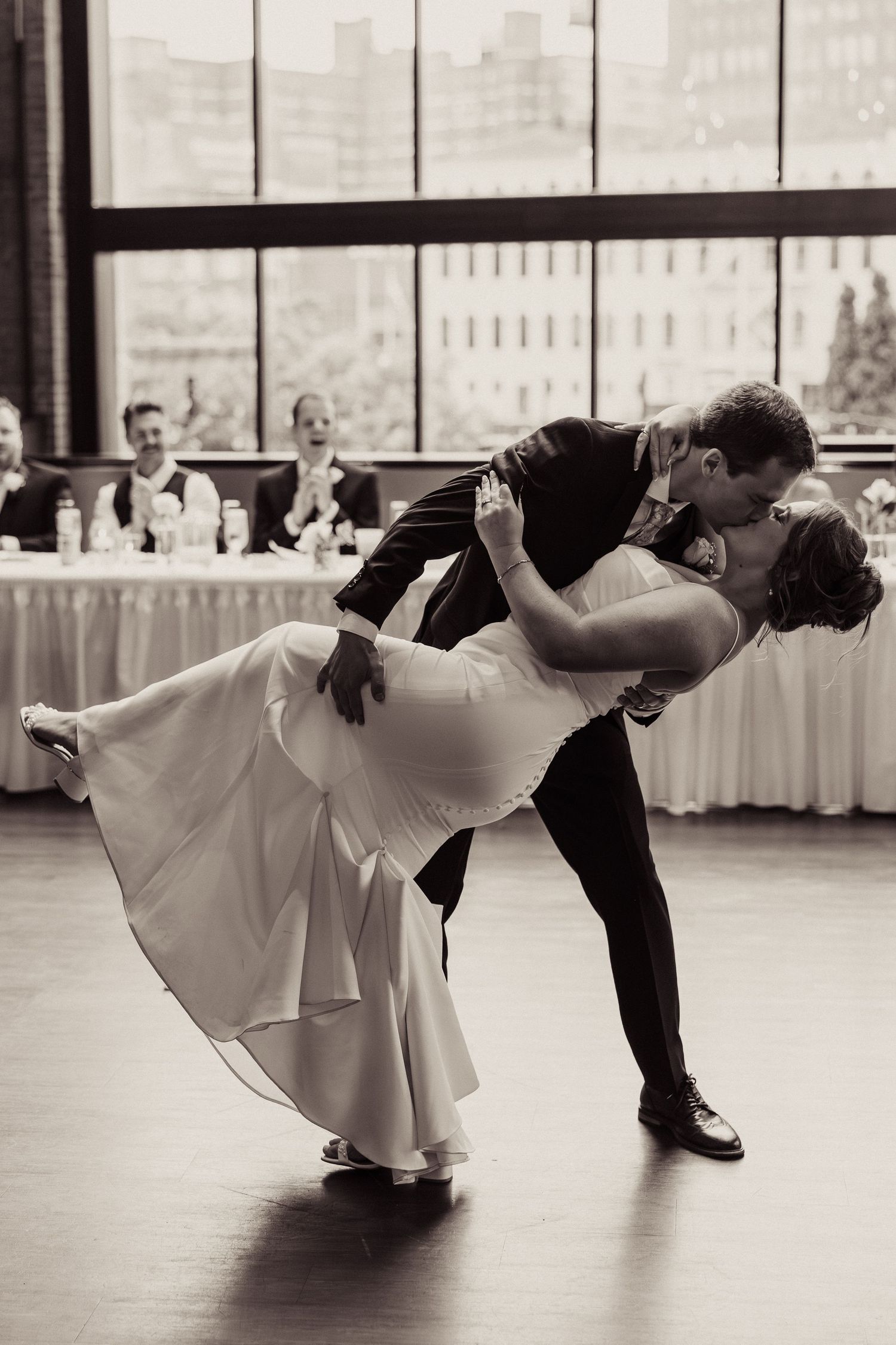 Dramatic black and white dance dip sequence in wedding reception venue.