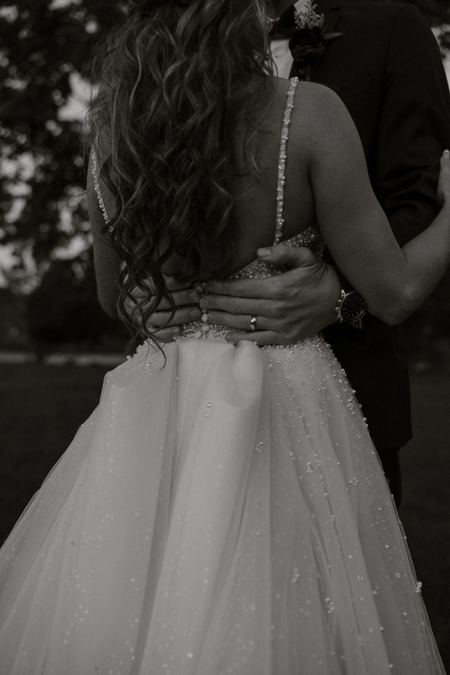 A series of black and white wedding photos showing close-up details of a bride's sparkly white ballgown dress.