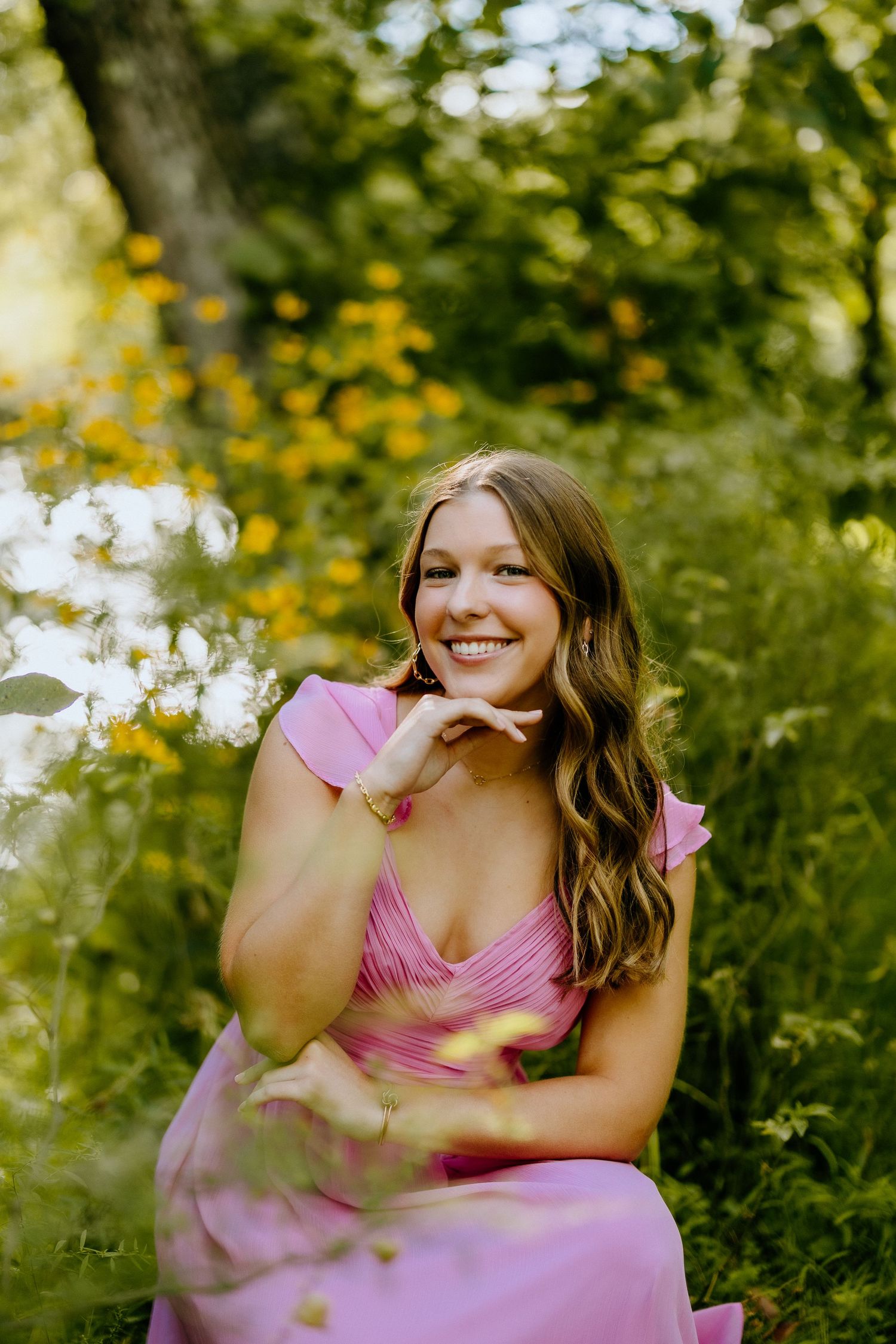A pink dress glows warmly in dappled sunlight among yellow wildflowers.