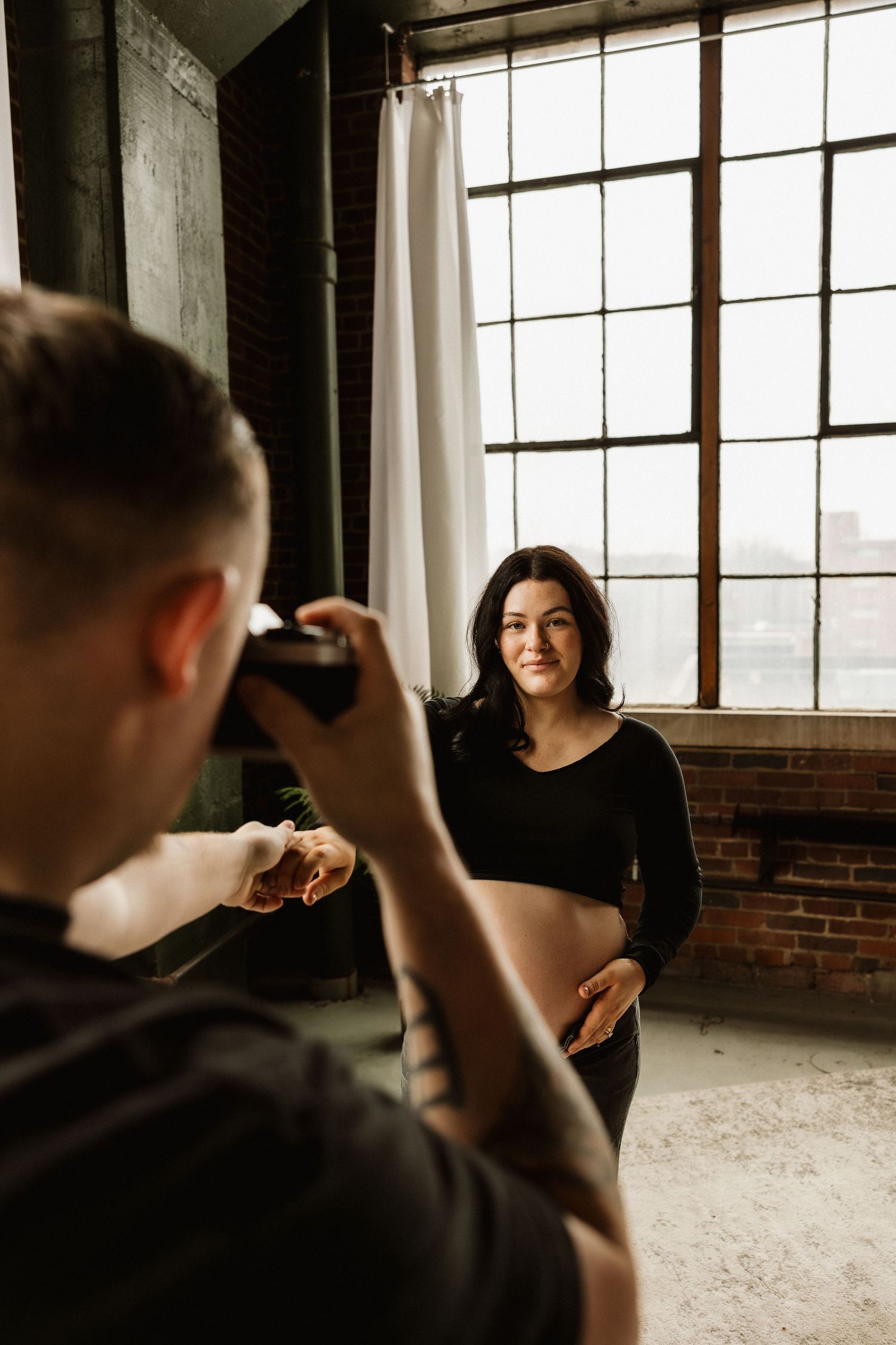 Behind-the-scenes photo shoot in an industrial loft space with natural window lighting.