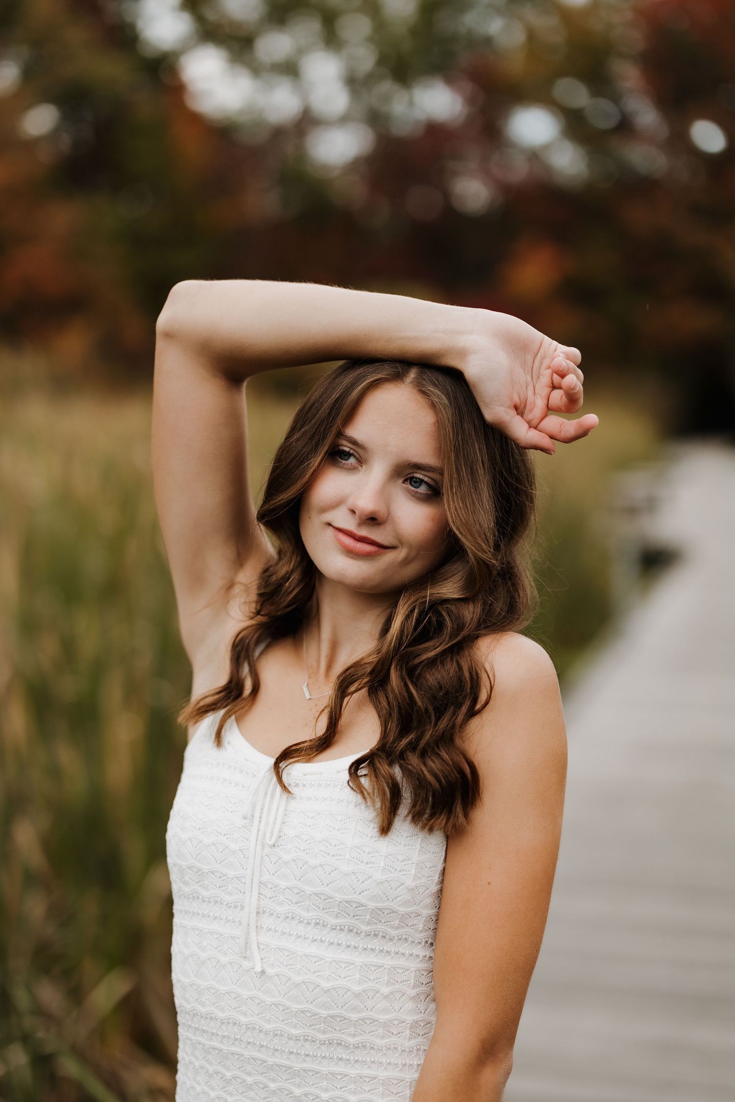 Natural outdoor portrait with soft autumn bokeh and warm lighting.