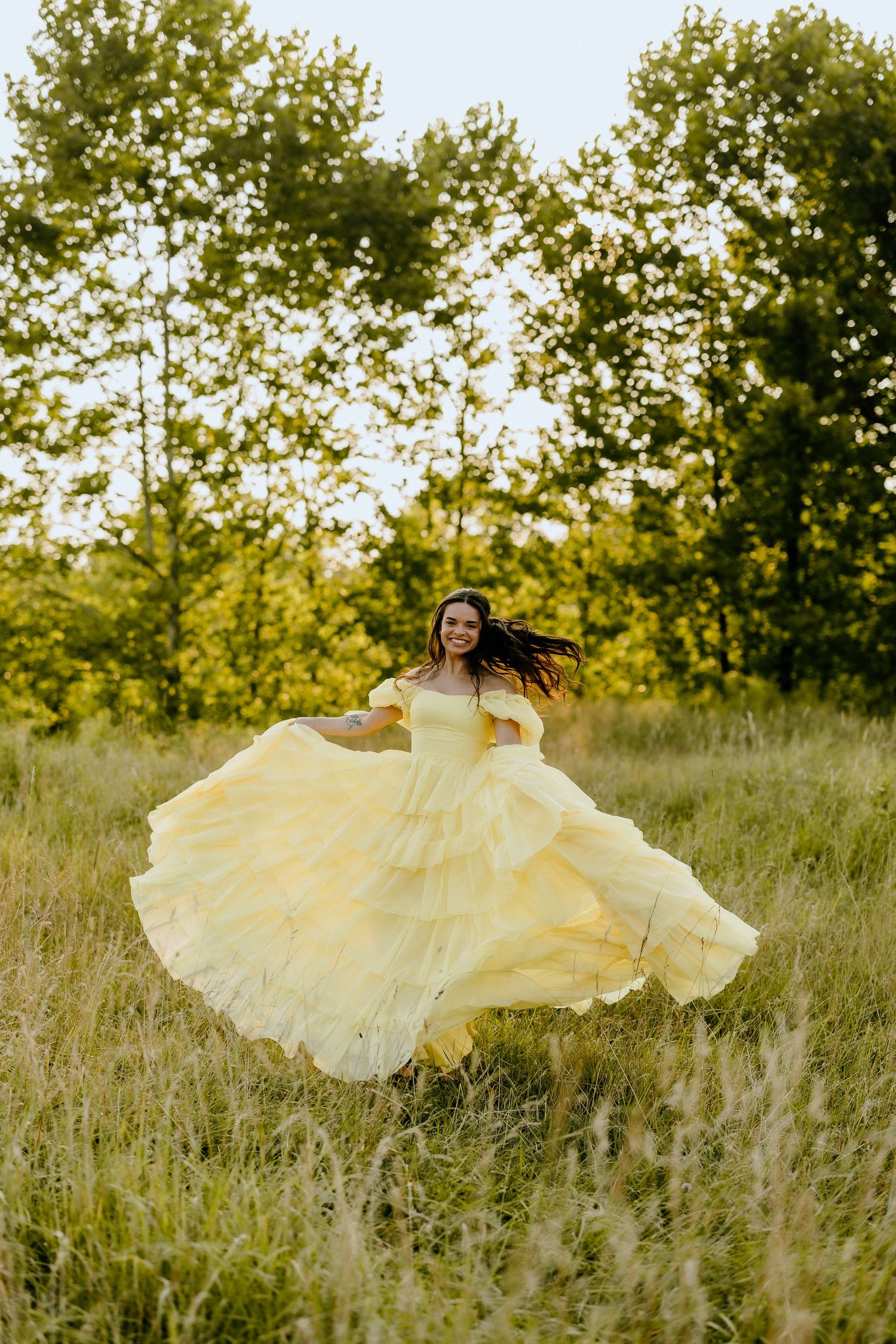 Twirling yellow princess dress captures movement in golden meadow.