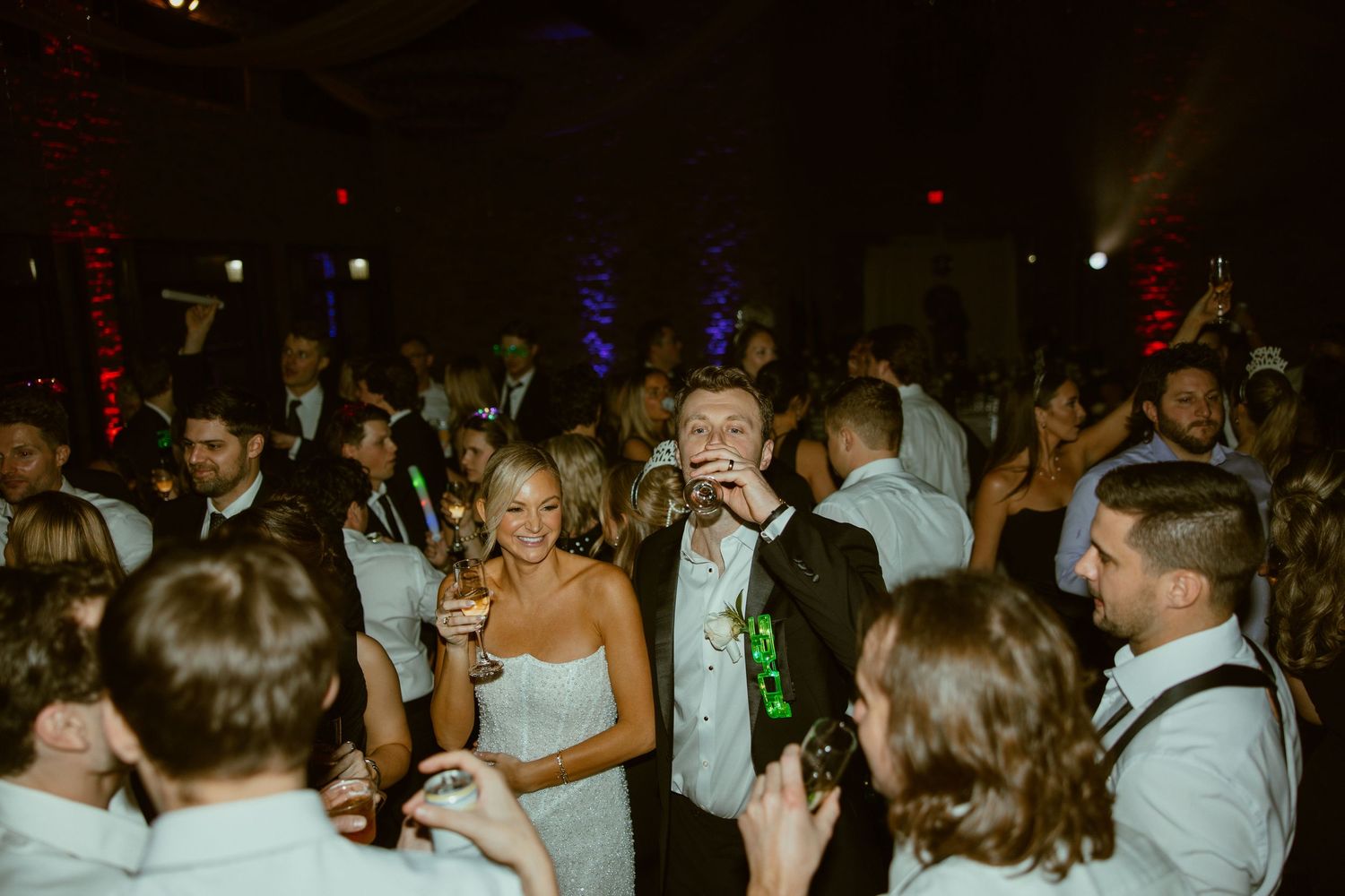 A crowded dance floor filled with people dancing and celebrating at a party or wedding reception.