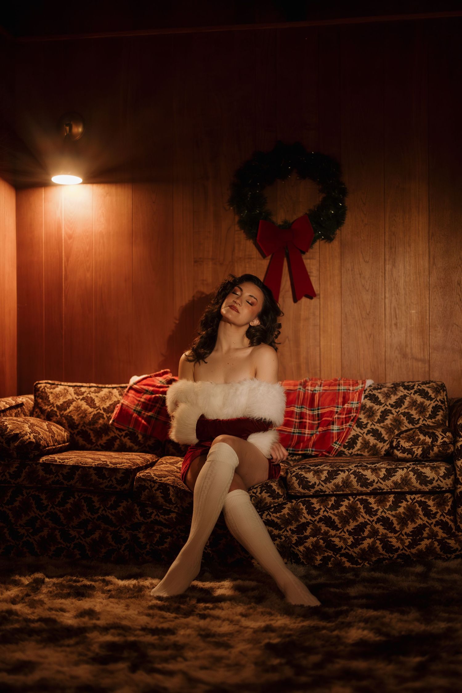A cozy holiday scene with vintage furniture and Christmas wreath in warm lighting.