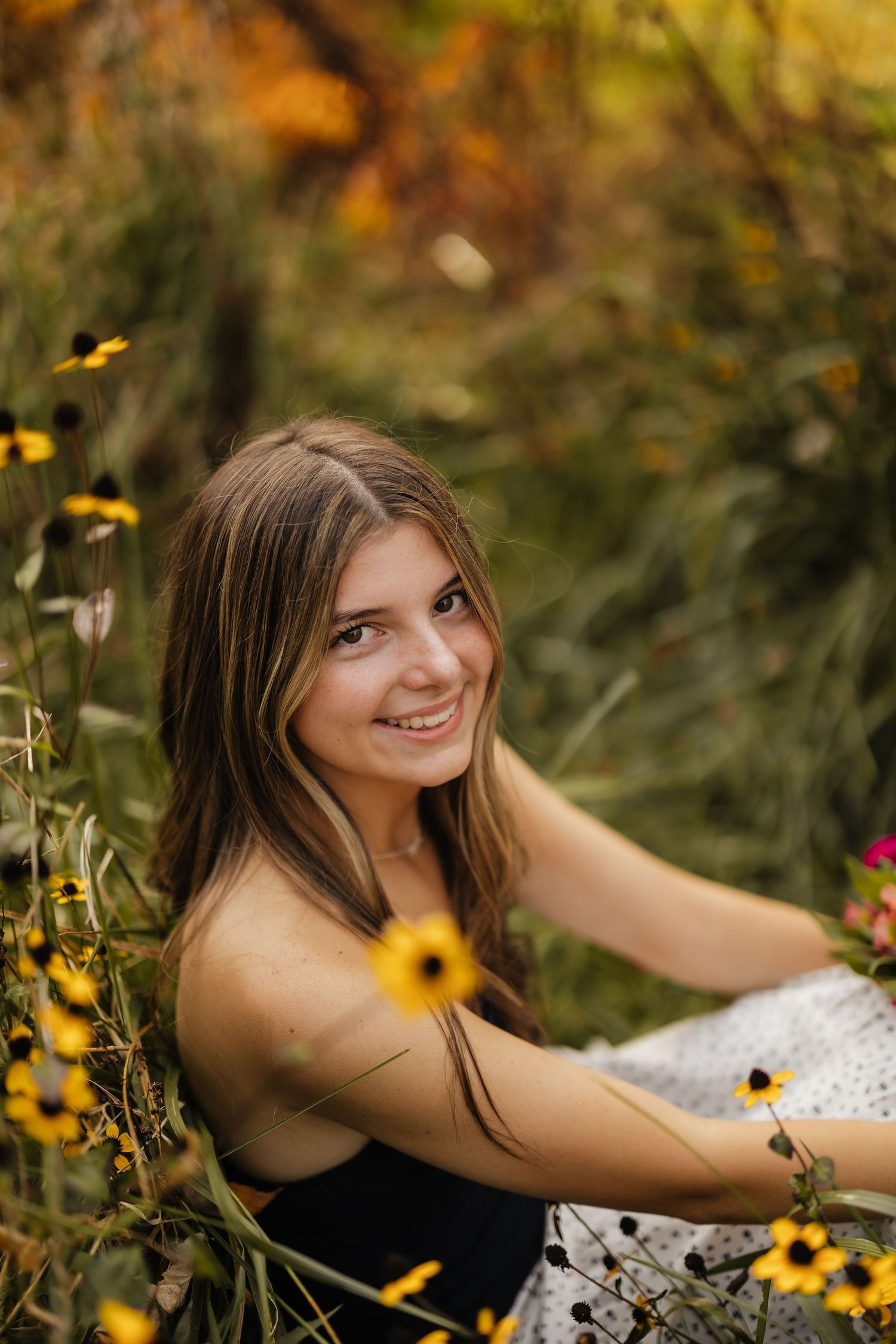 A summer portrait amidst blooming yellow wildflowers in a natural outdoor setting.