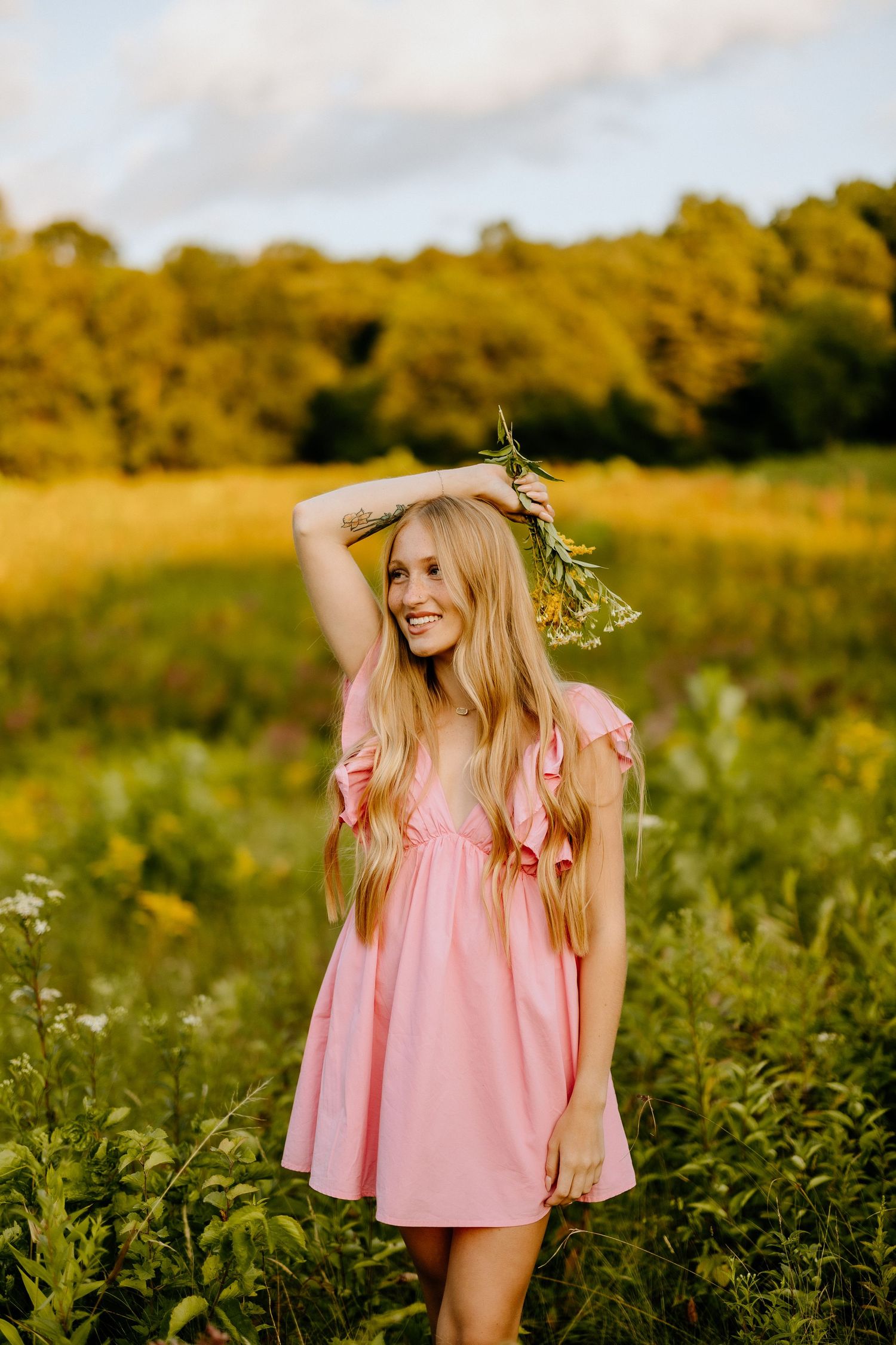 A pink ruffled dress twirls in a golden summer meadow with wildflowers.