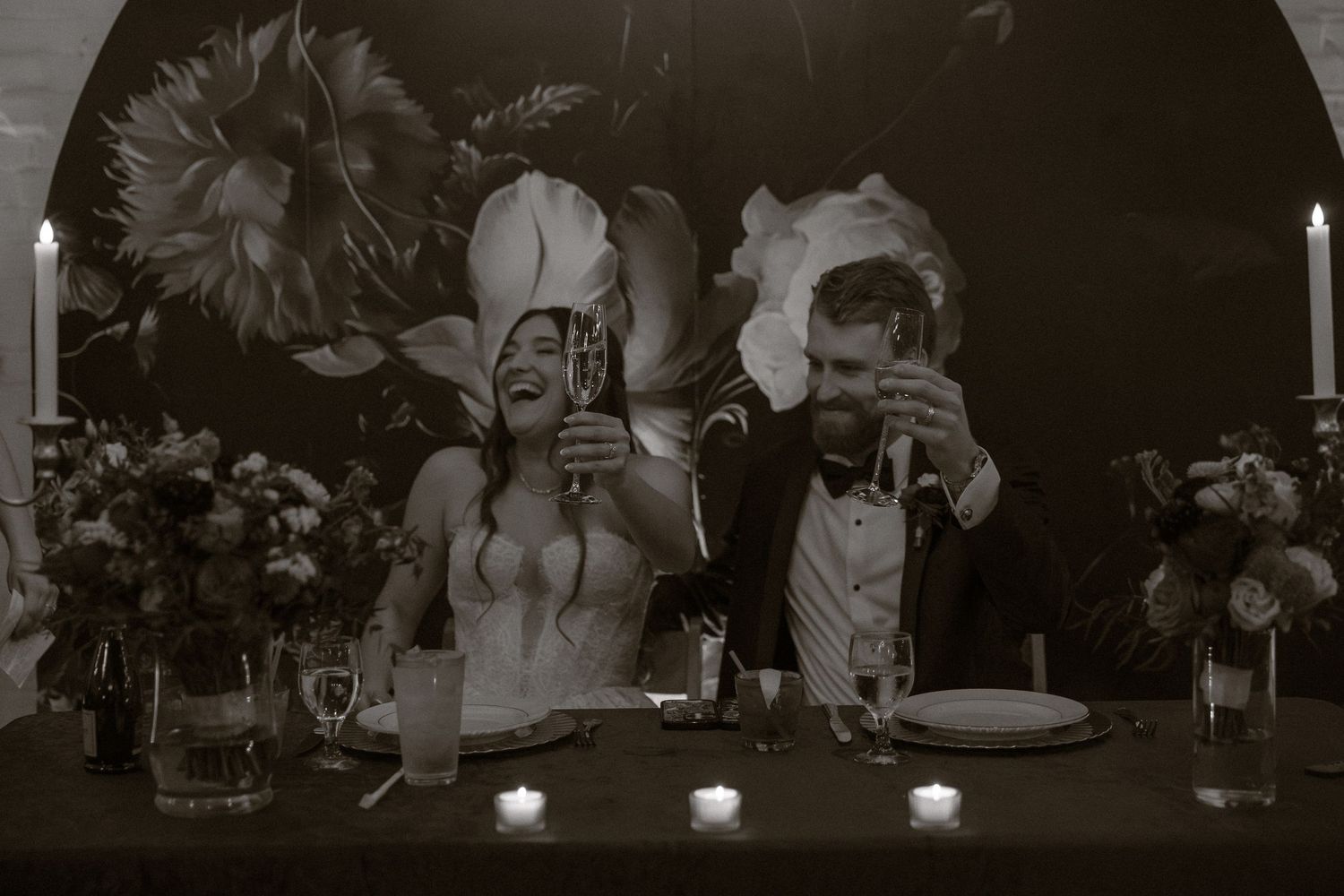 A series of black and white wedding reception photos showing guests dining and celebrating at decorated tables.