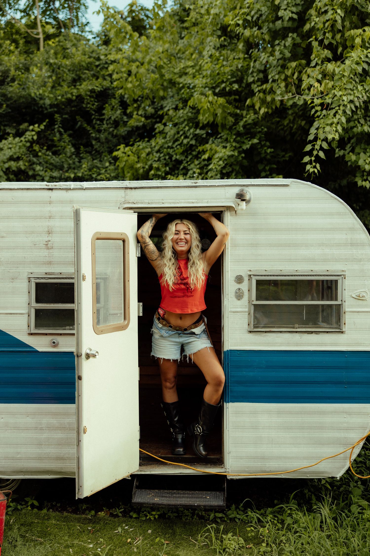 A series of shots showing someone playfully posing through the window of a vintage white travel trailer.