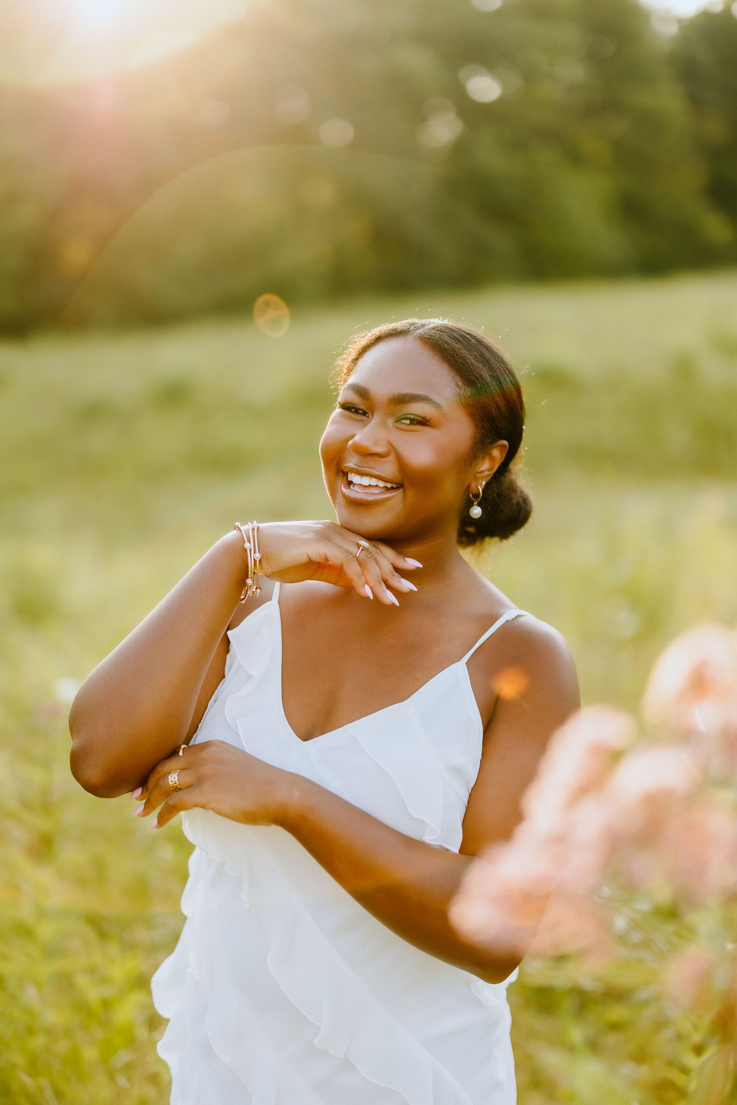 Sunset portrait in white dress with golden sunlight and natural backdrop.
