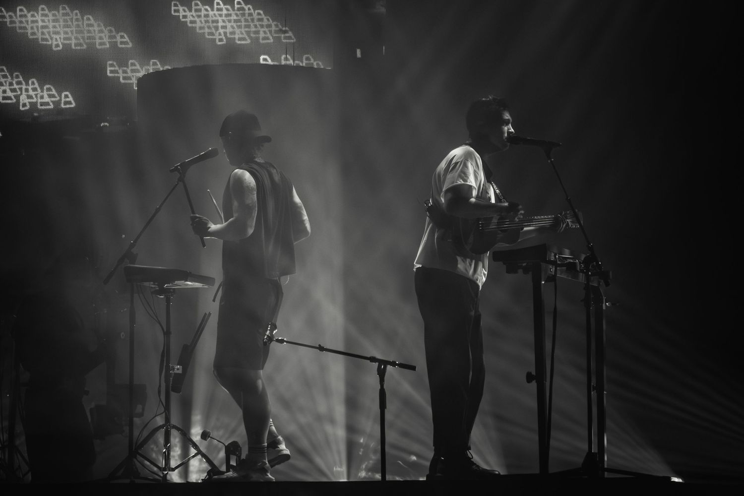 Musicians perform on a misty stage with dramatic backlighting creating silhouettes.