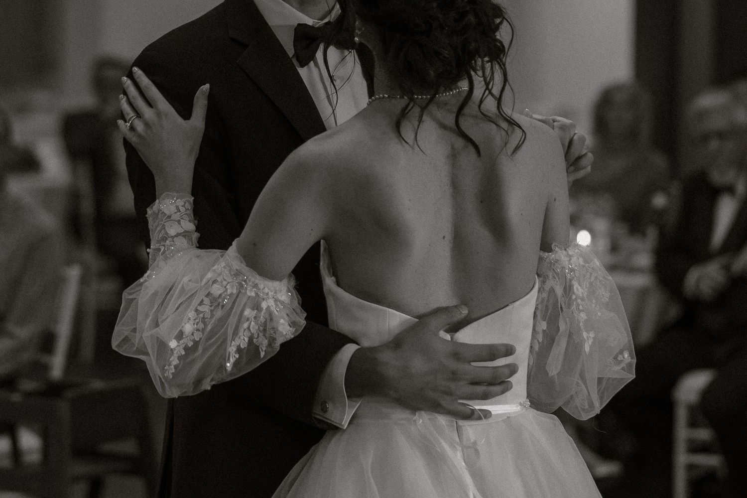 Black and white photo montage showing candid moments from a wedding celebration with dancing and embraces.