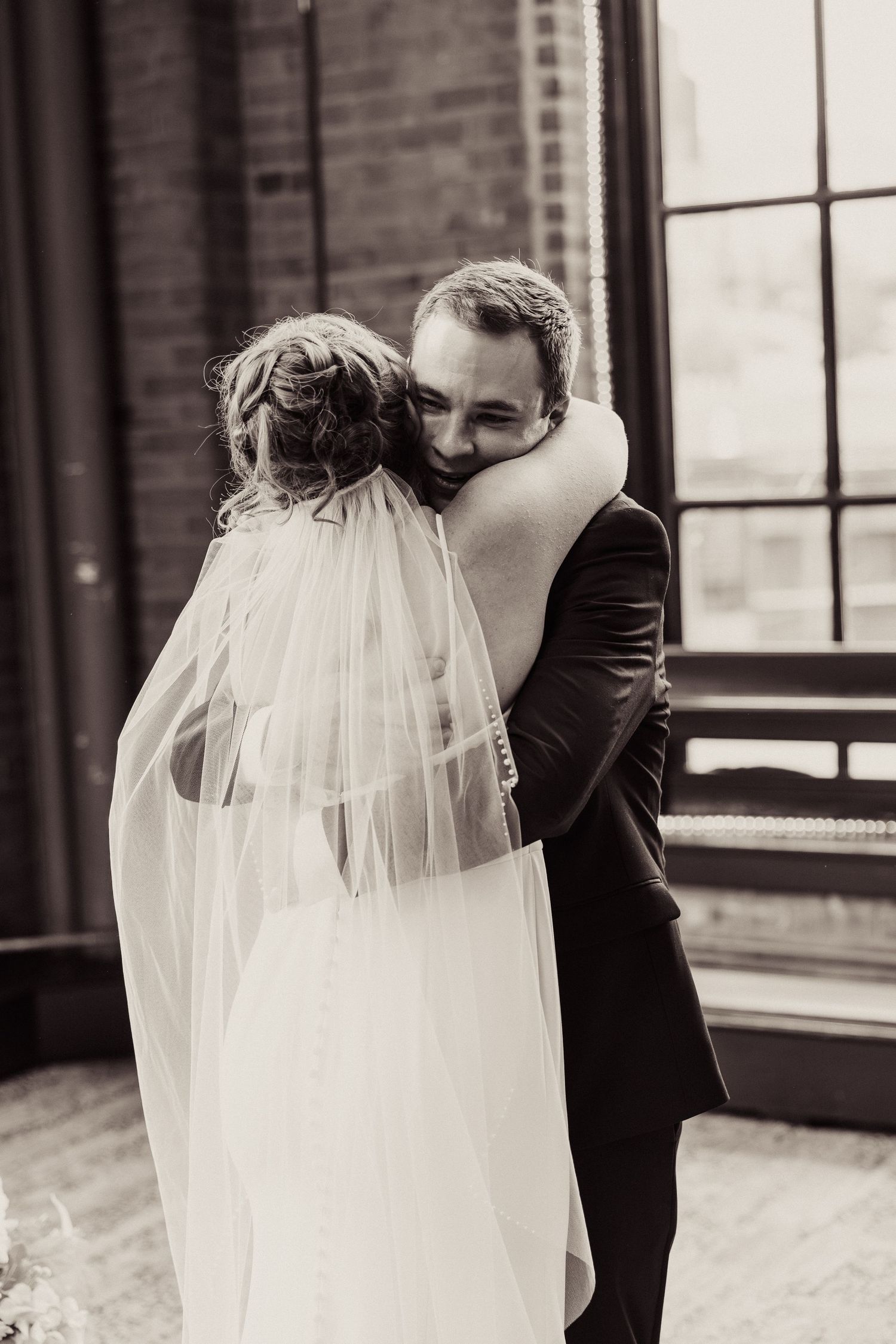 Black and white romantic wedding portraits showing tender moments through a veil.