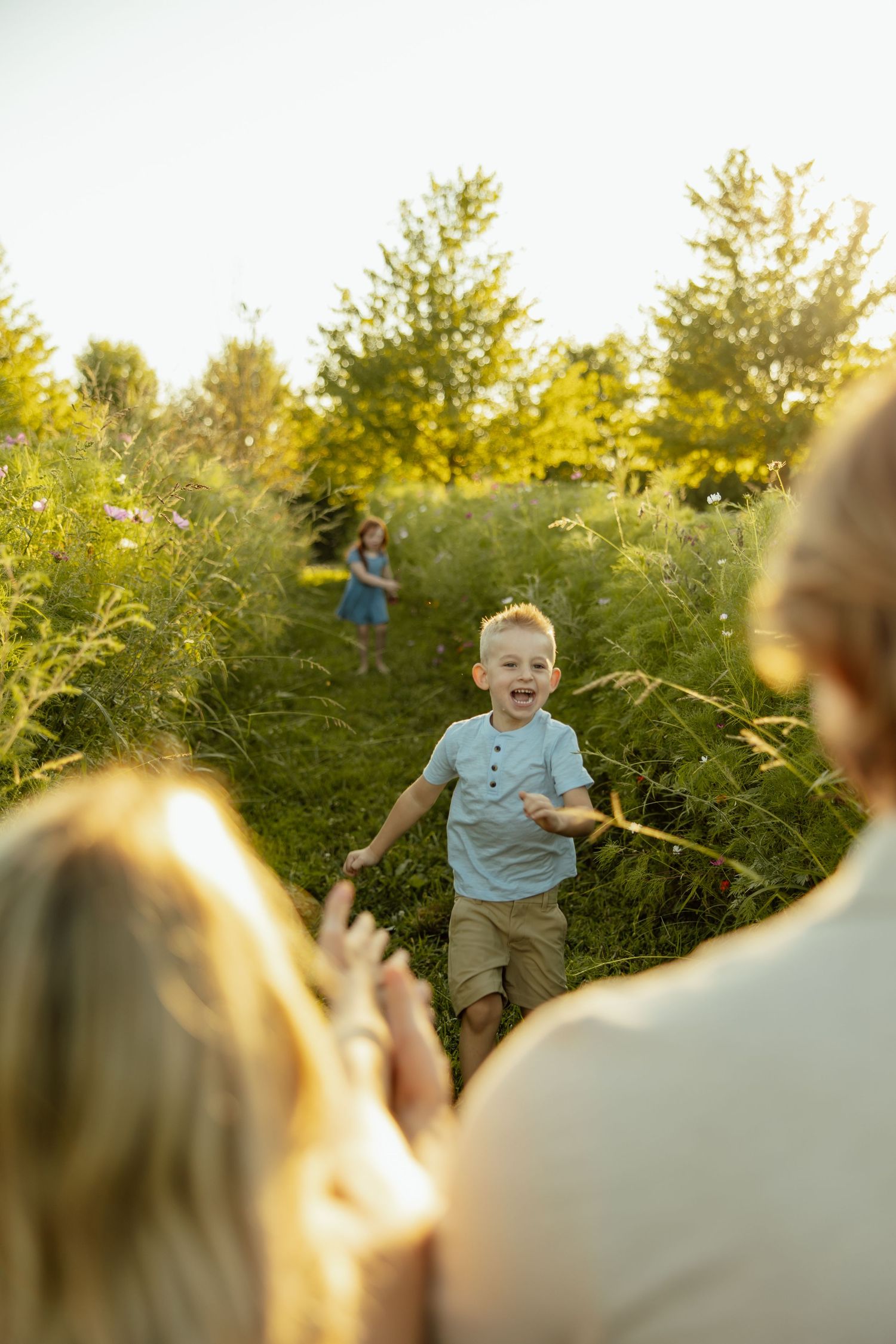 A series of four candid outdoor photos showing joyful moments between family members at sunset in a lush garden setting.