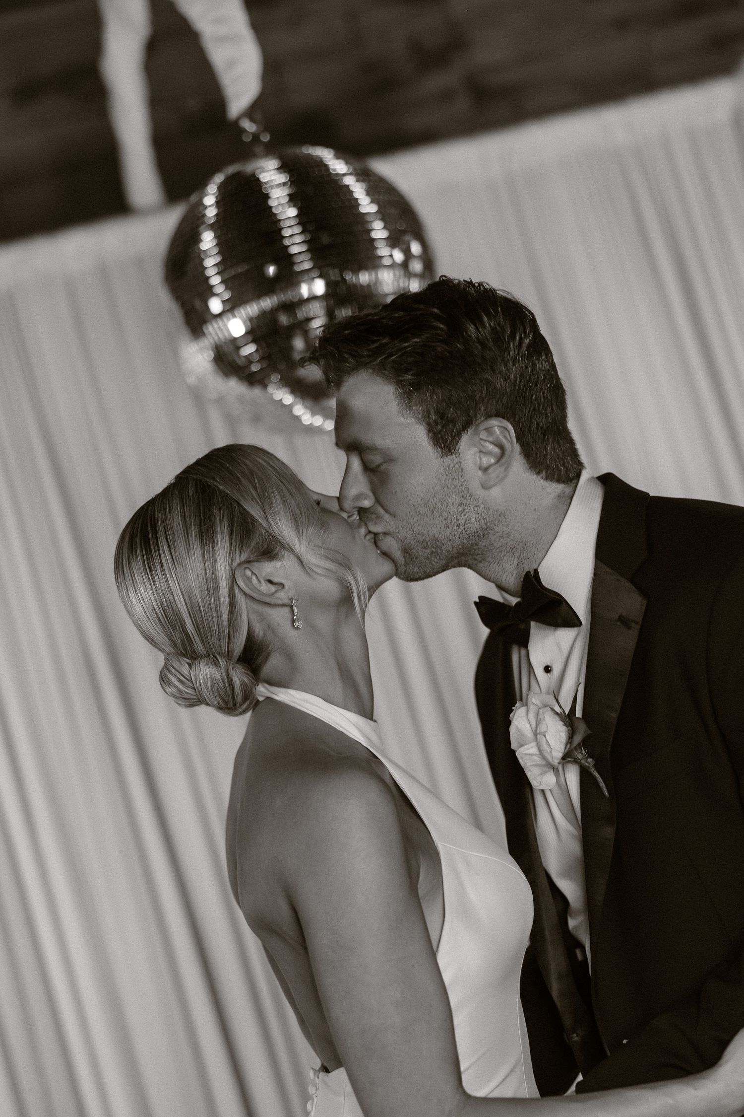 Intimate black and white portrait of couple sharing romantic moment at wedding reception.