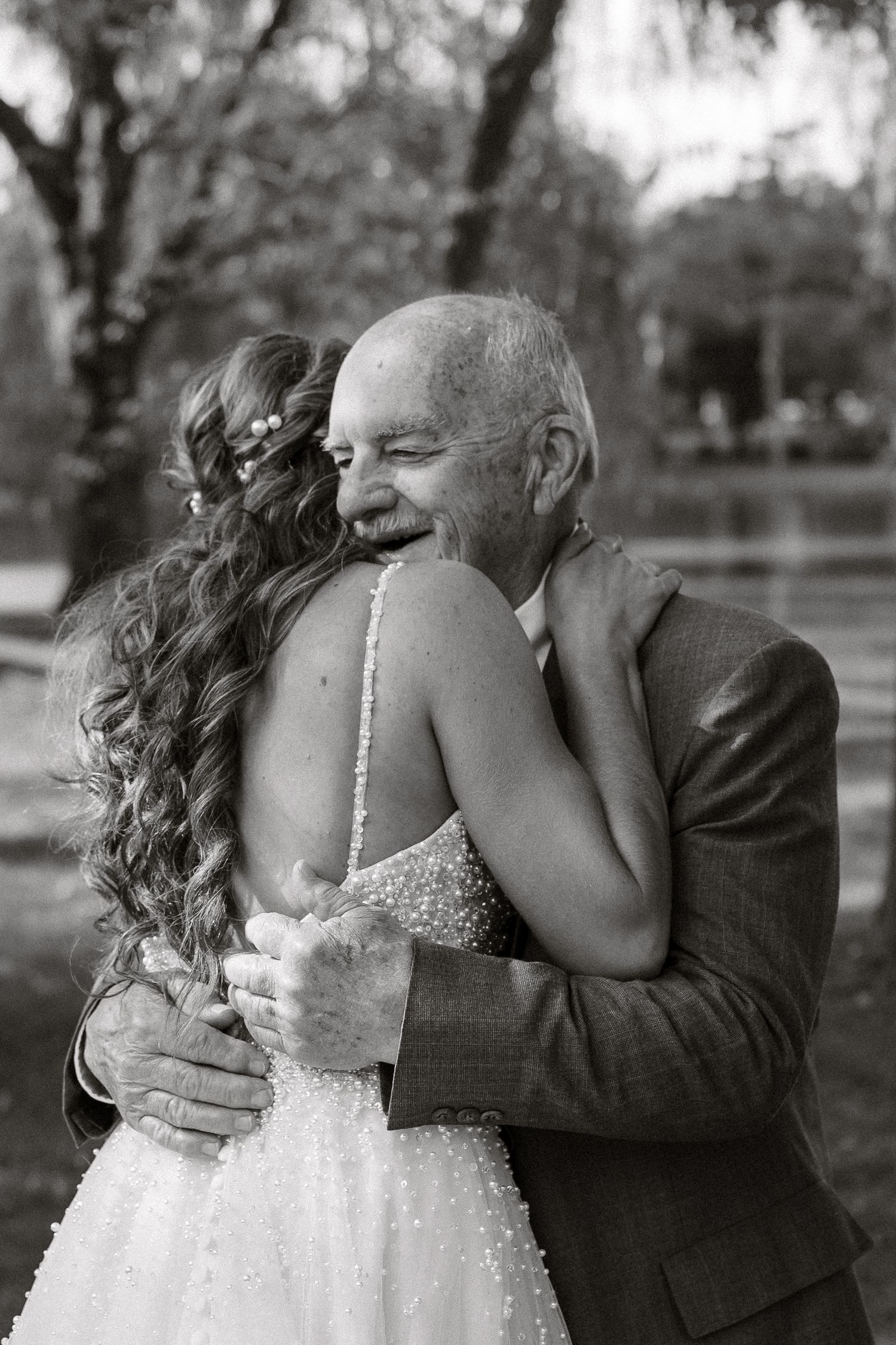A series of black and white wedding photos showing an emotional first look moment between a bride and her father.