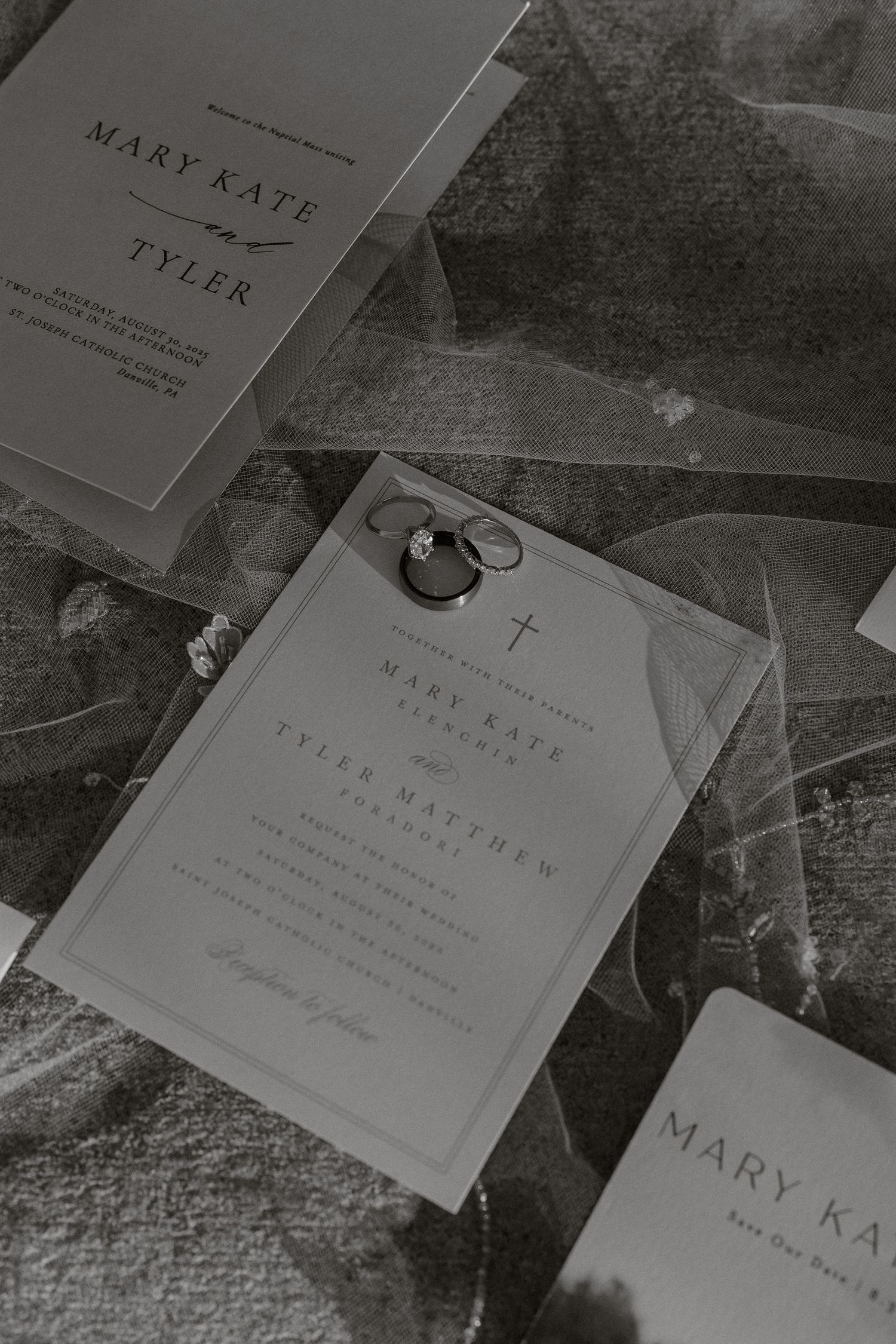 Wedding invitation suite in black and white with rings and cross details.