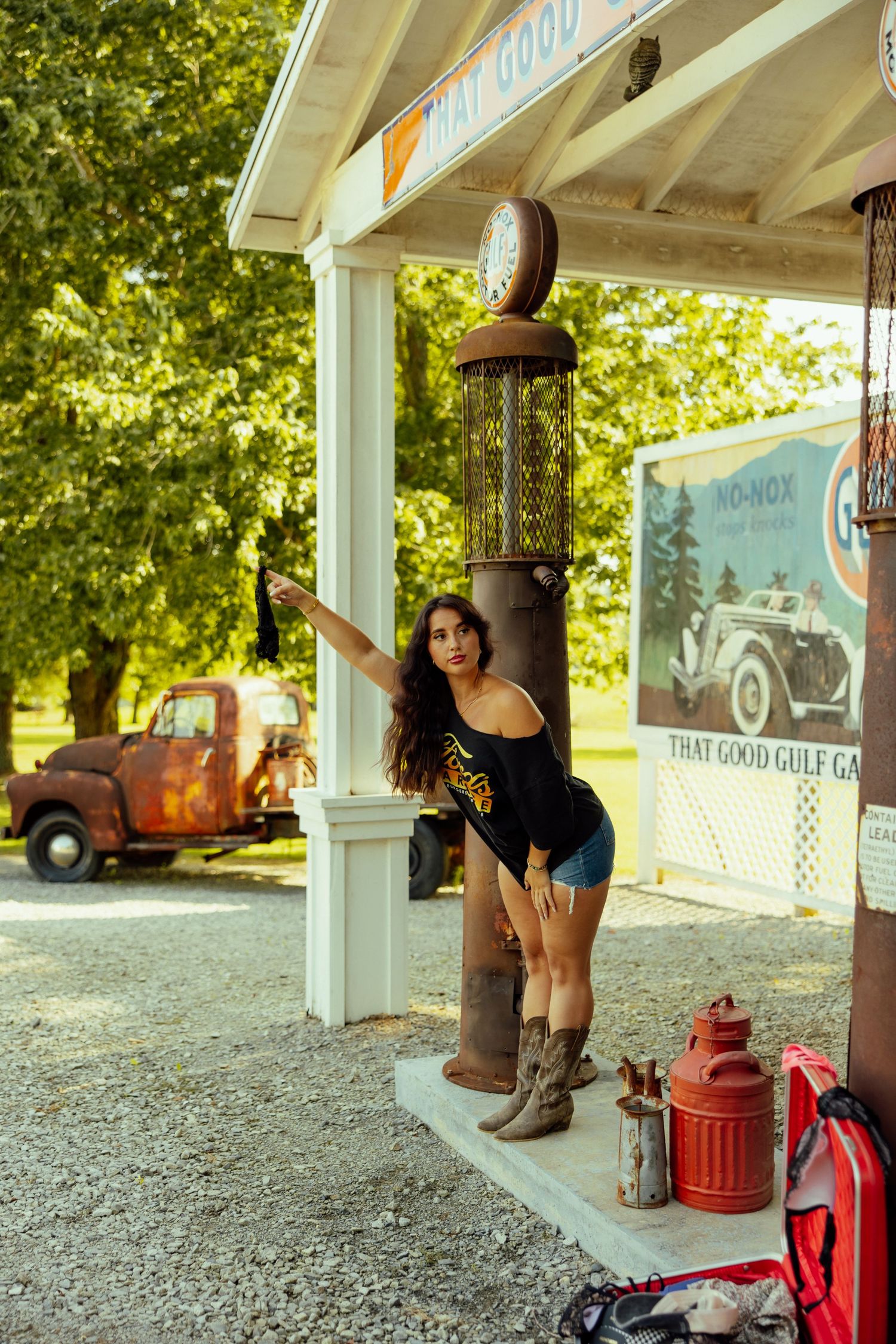 Vintage gas station scene with antique pump and rustic decor including old Gulf sign and red metal gas can.