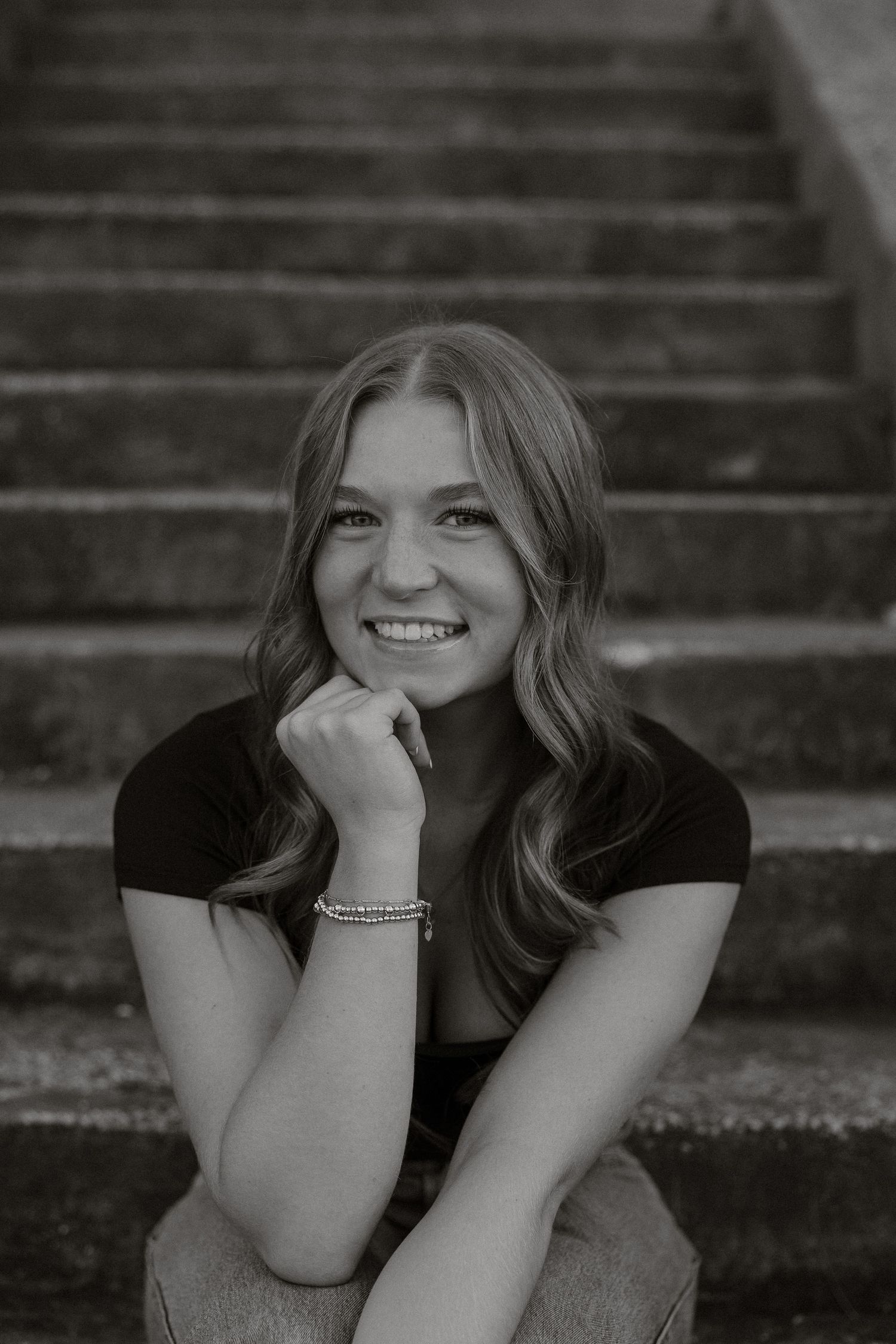 Black and white senior portrait on stone steps with casual poses and natural expressions.