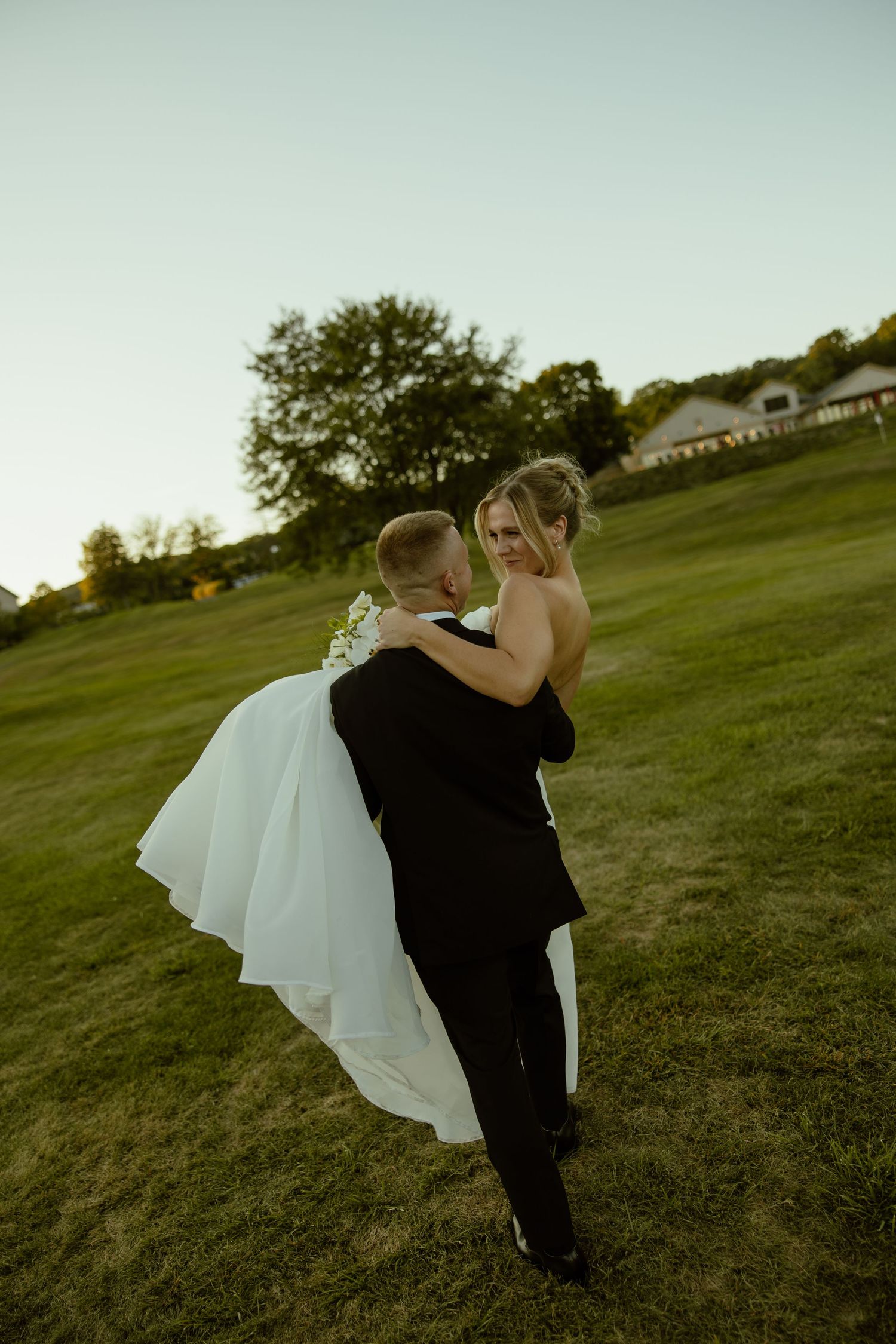 Artistic sequence of a couple dancing and twirling on a grassy hill at sunset.