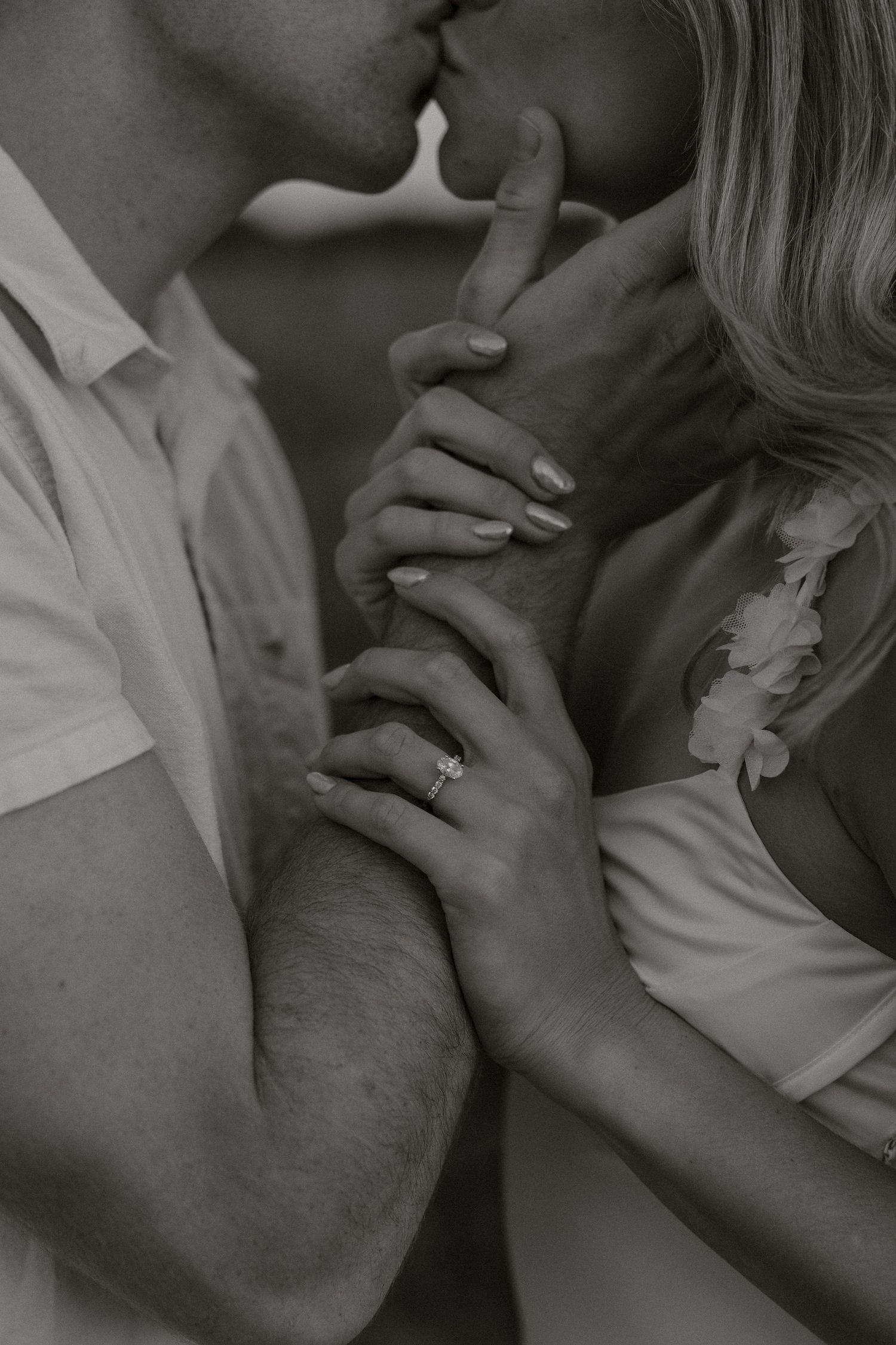 A romantic black and white photo sequence showing hands and an intimate kiss between a couple.