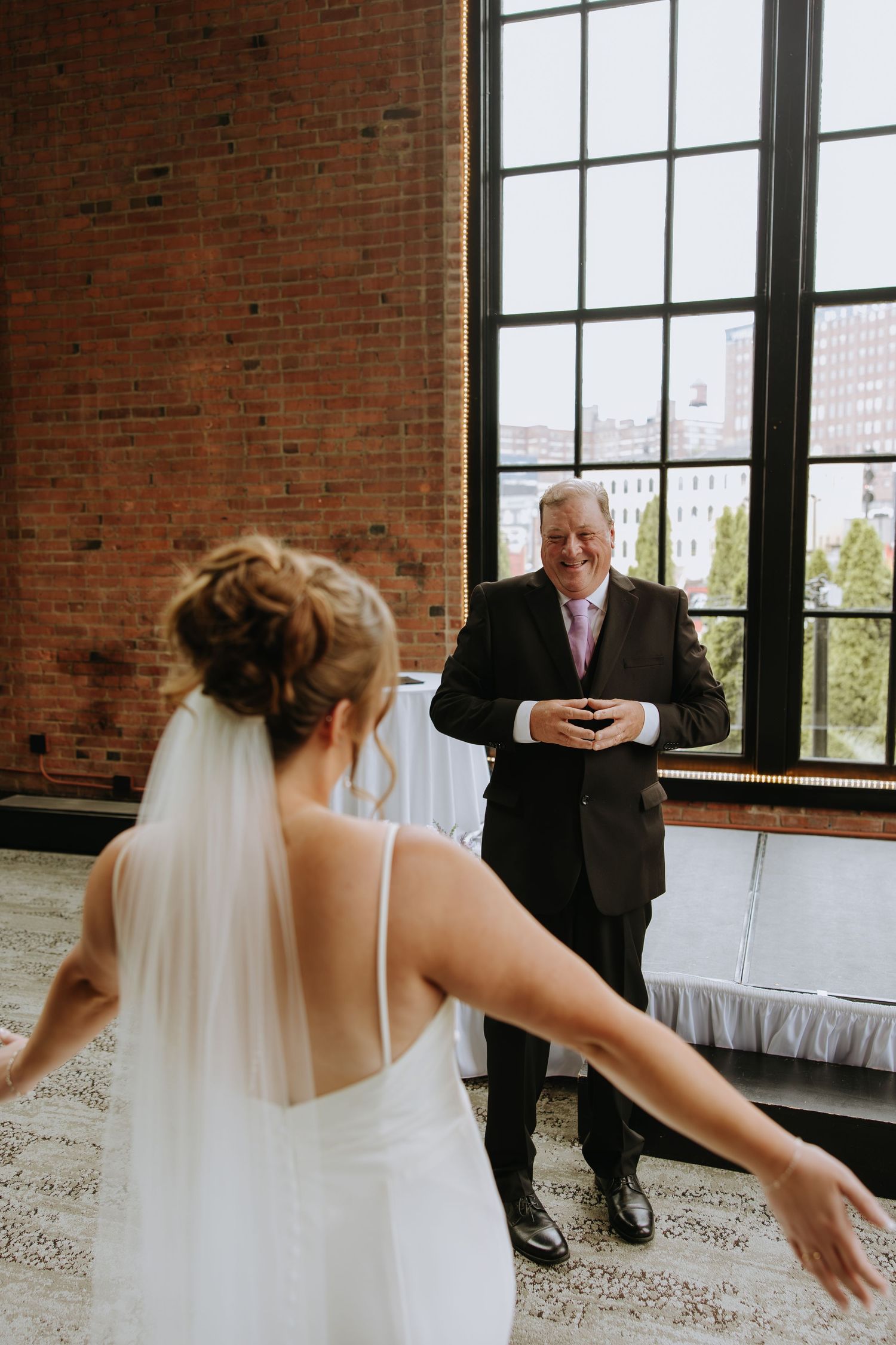 A sequence of wedding photos showing playful moments between a bride in white and a person in a suit in a brick-walled venue.