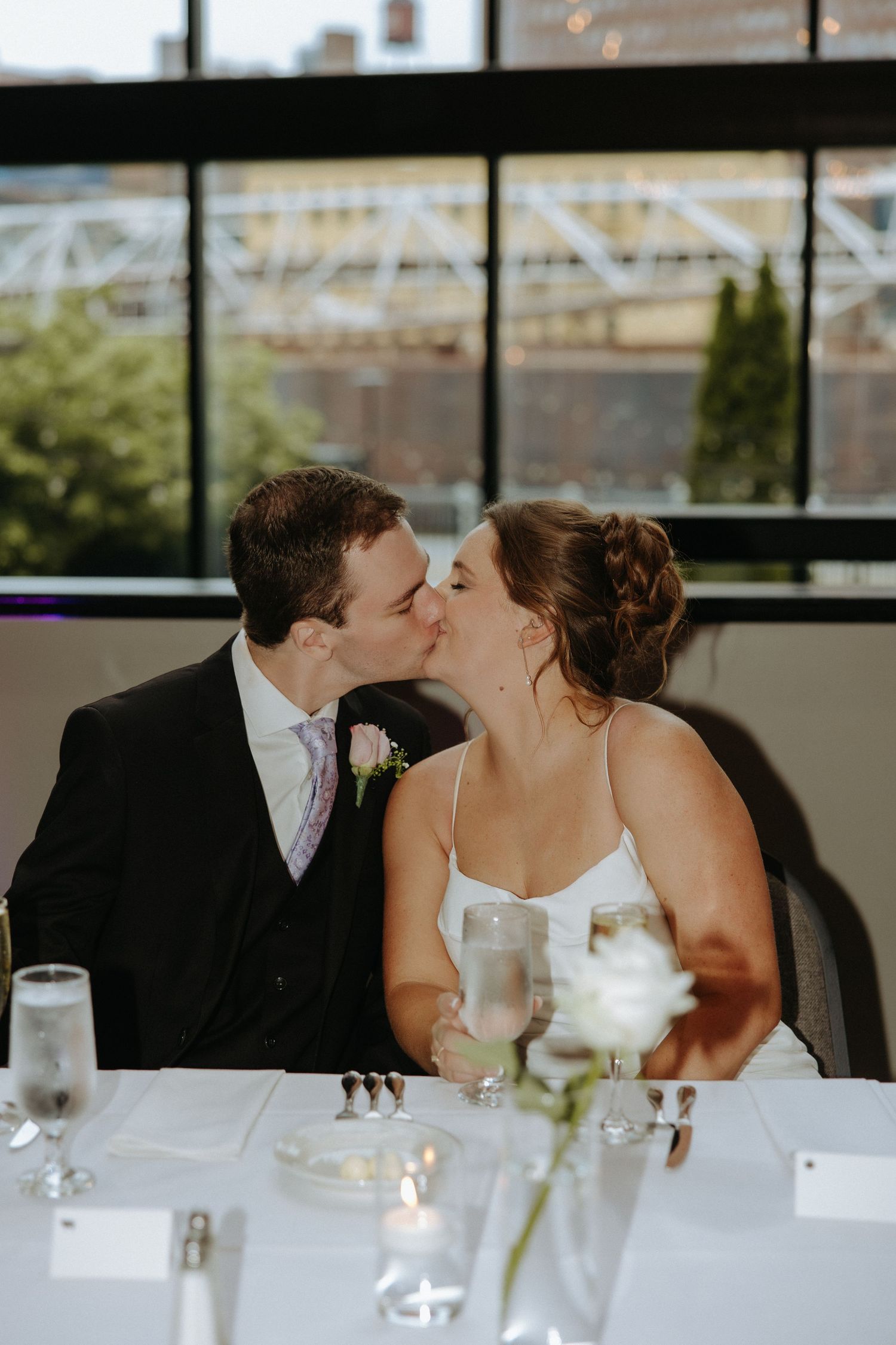 Romantic moment shared at an elegant wedding reception with waterfront views.