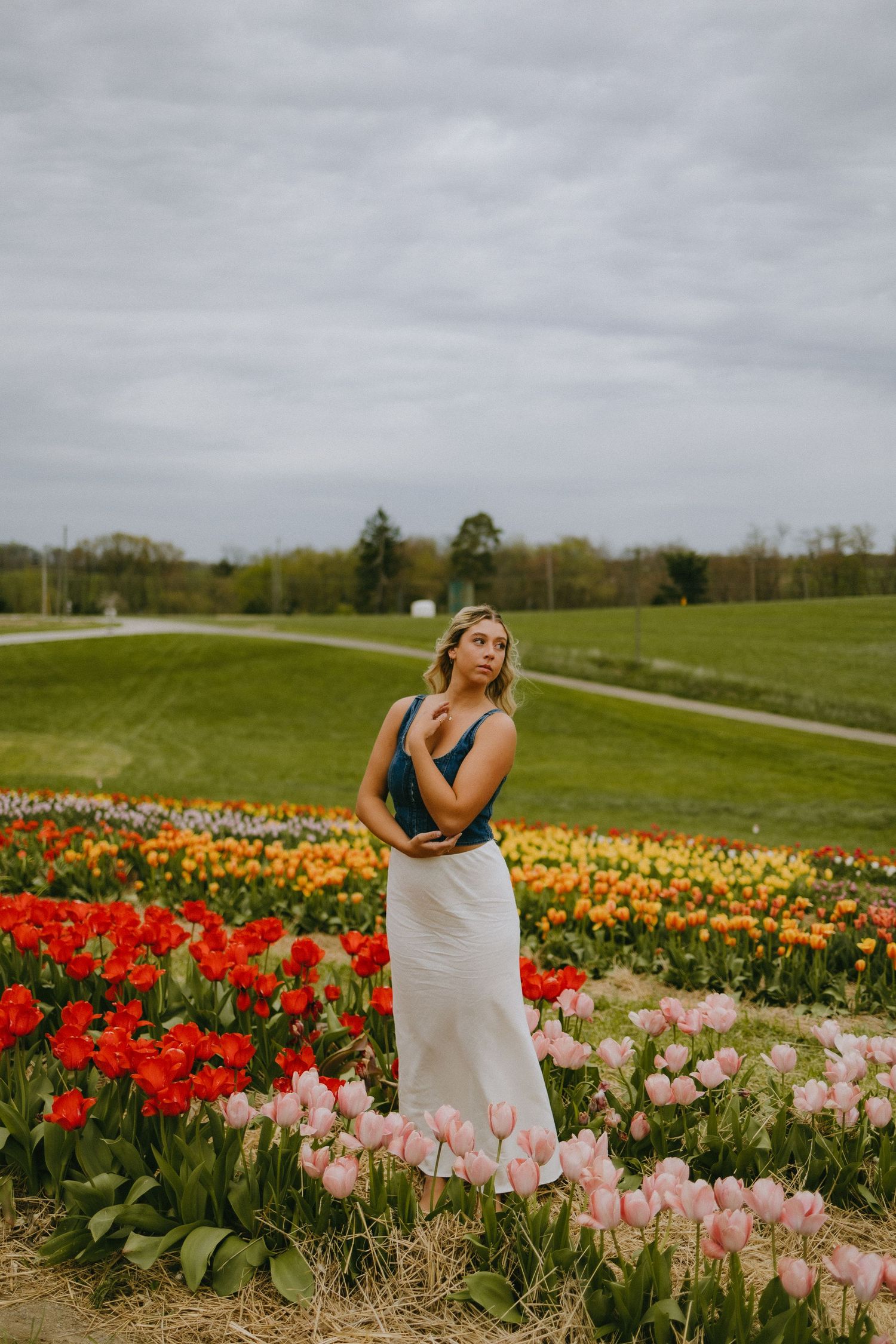 Spring portrait session in a colorful tulip garden with pink and red blooms.